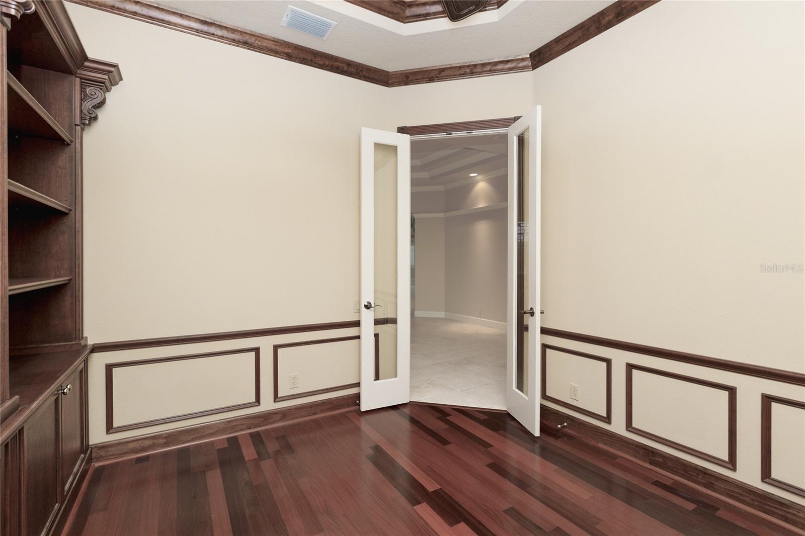 Office with built in bookshelves and double glass doors