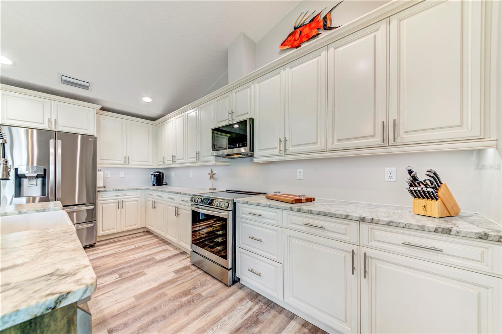 White Shaker Cabinets with Crown Molding, Leathered Granite Counters