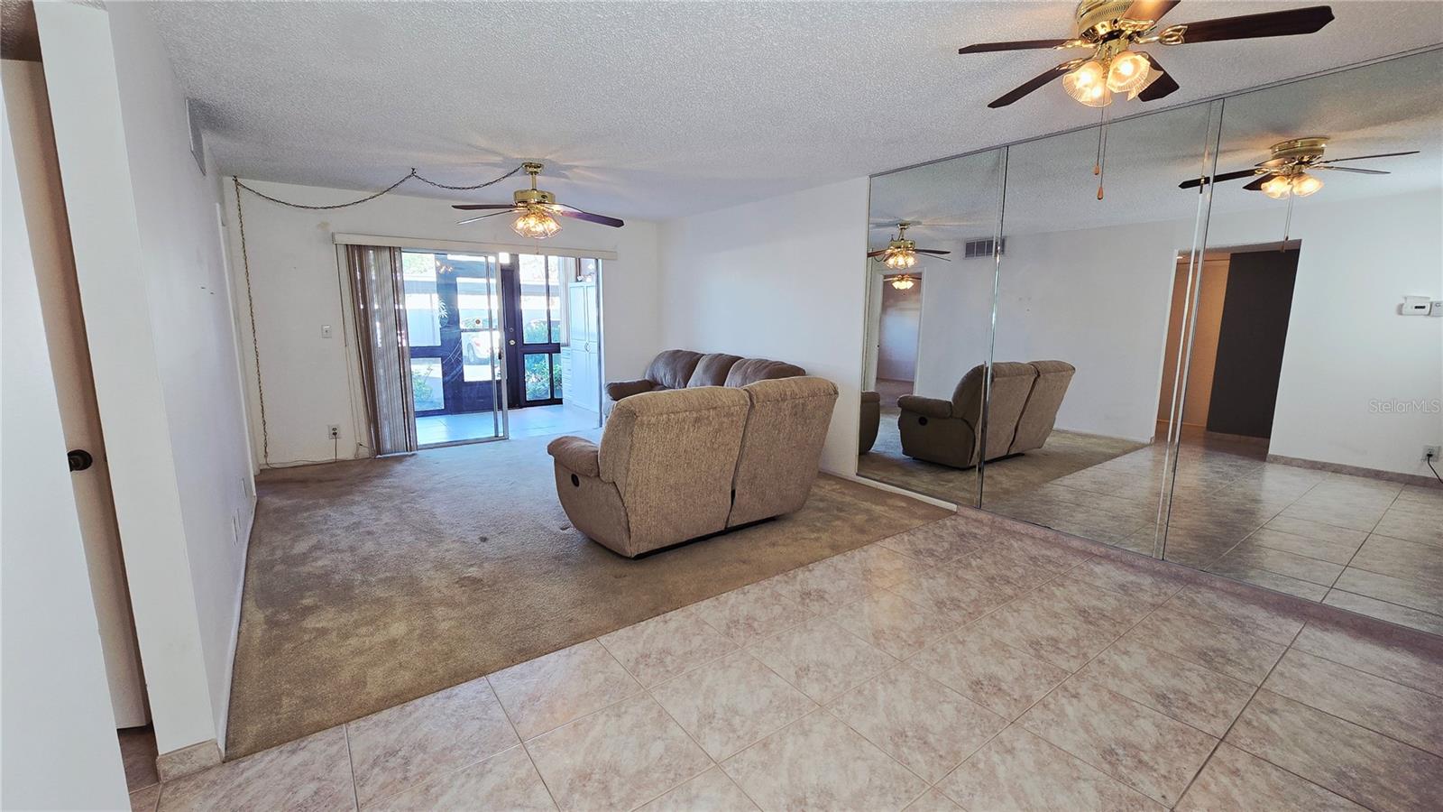 Dining Room/Living Room Combo with view of the rear enclosed patio and access to the back door with loads of natural lighting.