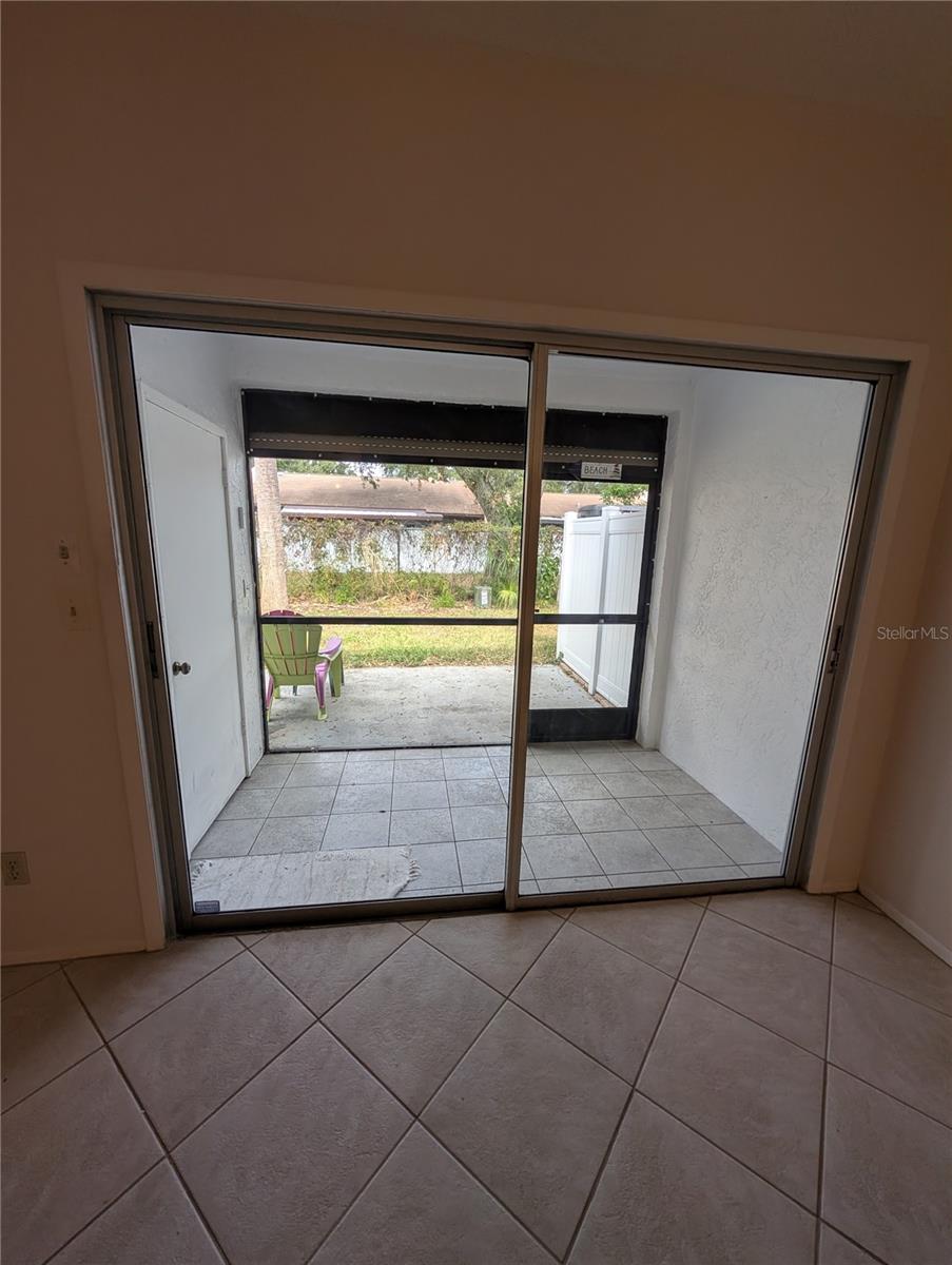 Sliders to the rear screen enclosed patio + storage closet