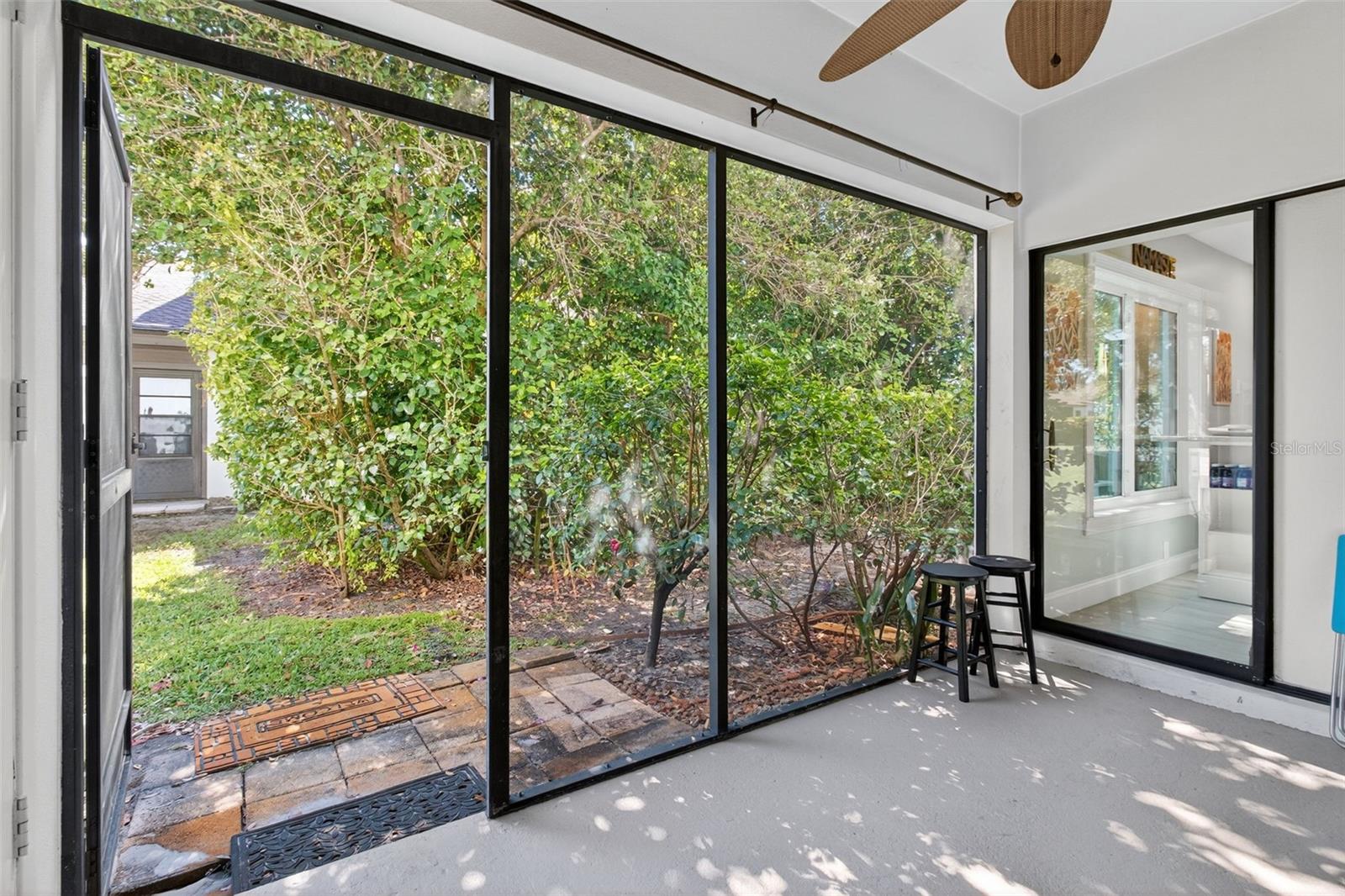 Large enclosed rear patio with storage and beautiful garden view.