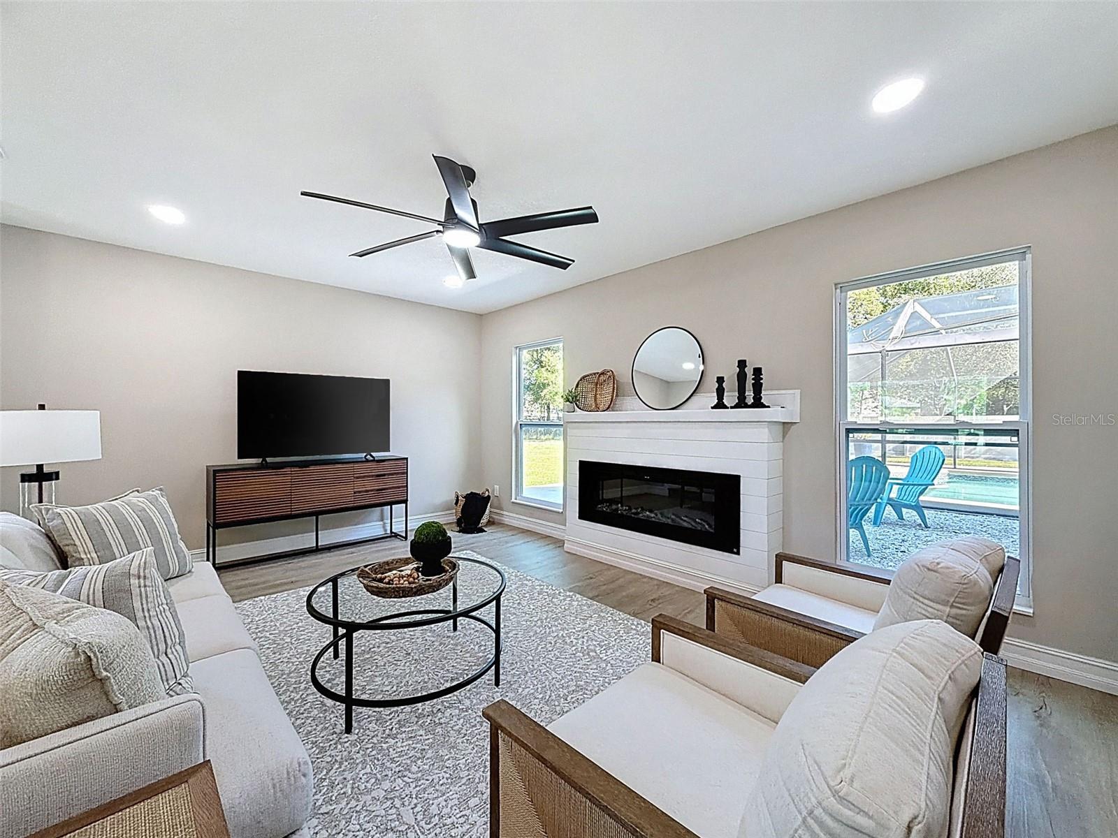 Spacious living room with electric fireplace.