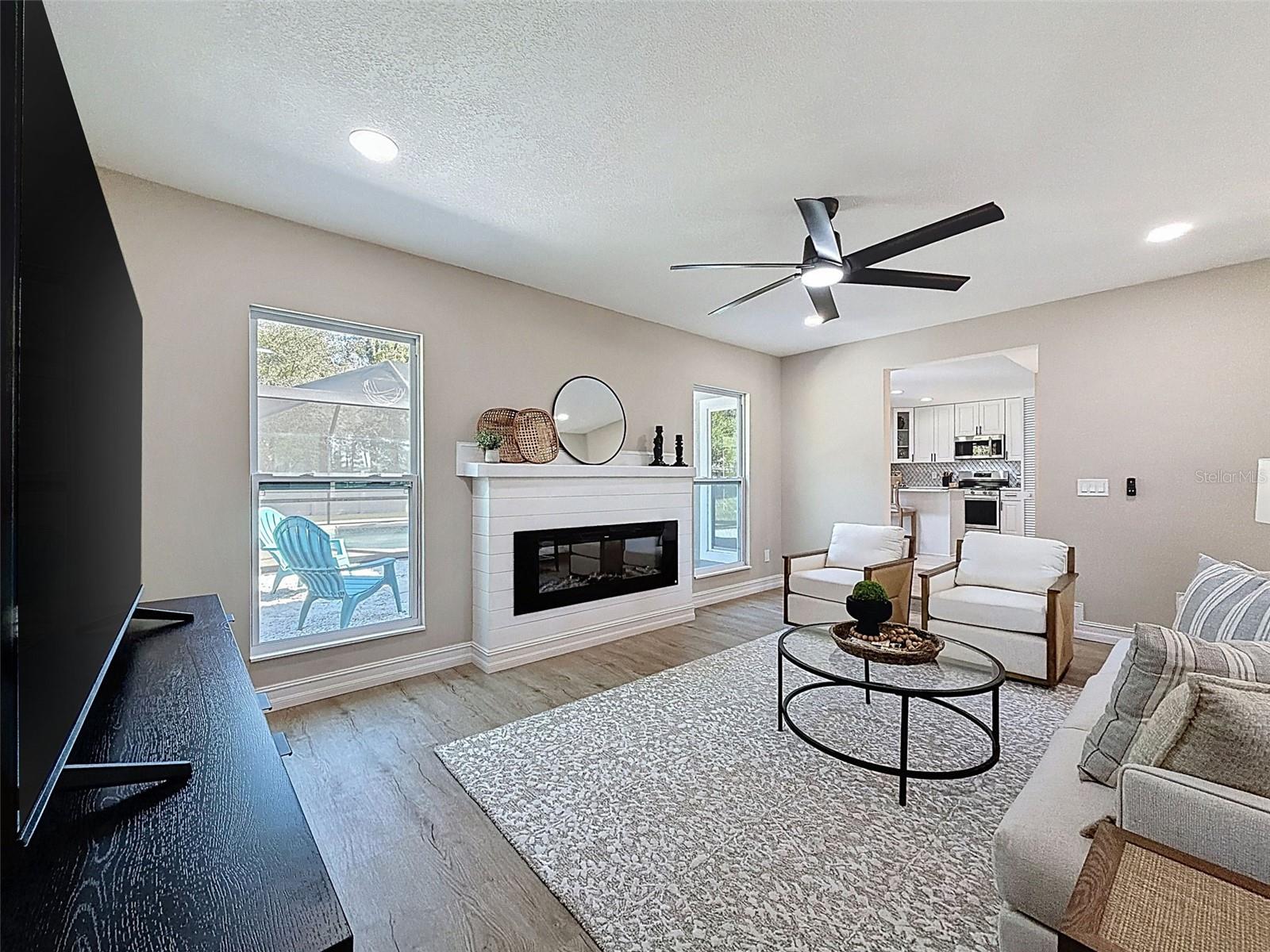 Spacious living room with electric fireplace.