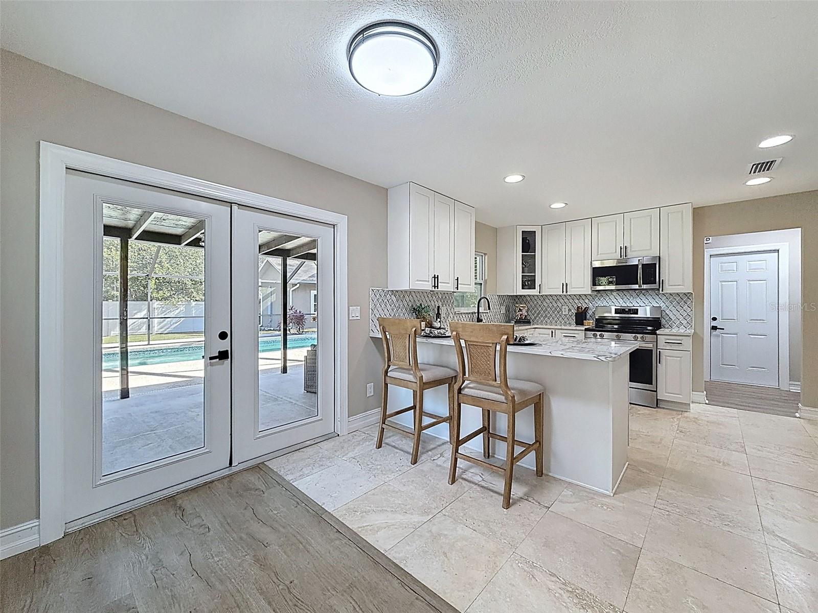 Modern kitchen with breakfast room overlooking the pool.