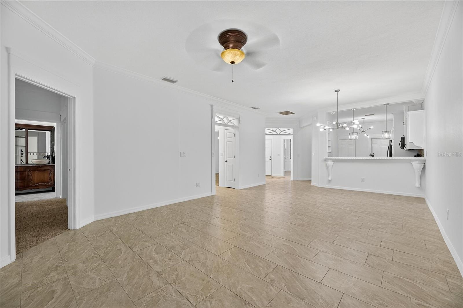 Looking into the living and dining room. Doorway on the left leads to the owner's suite. The door in the middle leads to the guest suite.