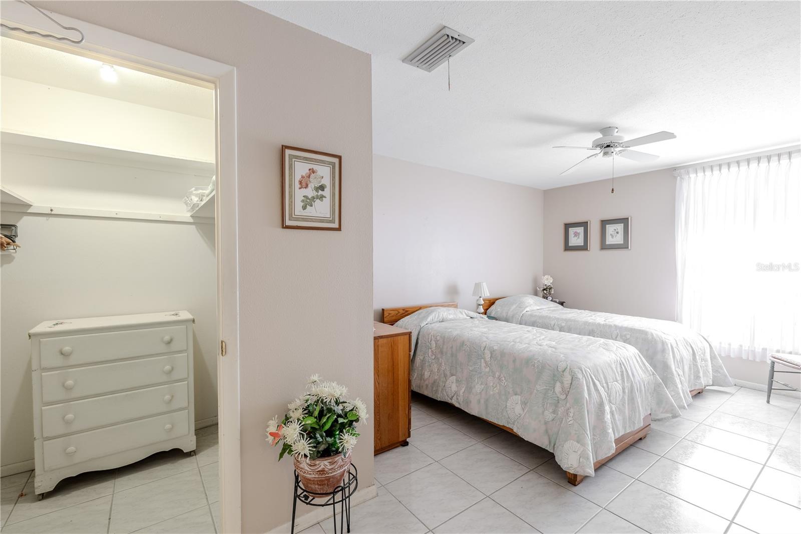 Bright and welcoming master bedroom with a large window that lets in abundant natural light. A ceiling fan ensures comfort, and the spacious walk-in closet provides plenty of storage. This thoughtfully designed retreat offers a cozy, functional space perfect for rest, relaxation, and everyday living.
