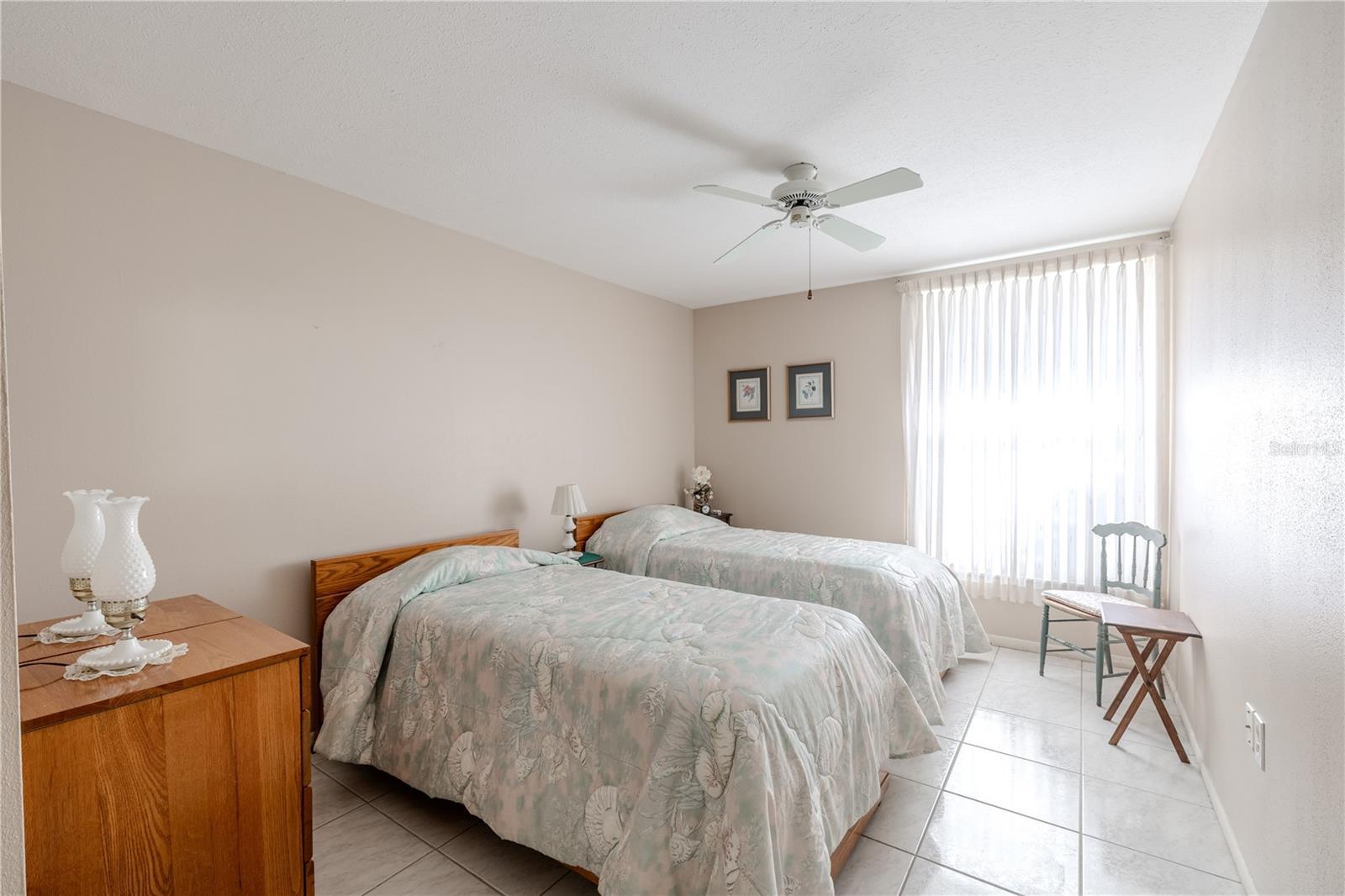 This full view of the master bedroom room reveals the bright and welcoming master bedroom with a large window that lets in abundant natural light. A ceiling fan ensures comfort. This thoughtfully designed retreat offers a cozy, functional space perfect for rest, relaxation, and everyday living.
