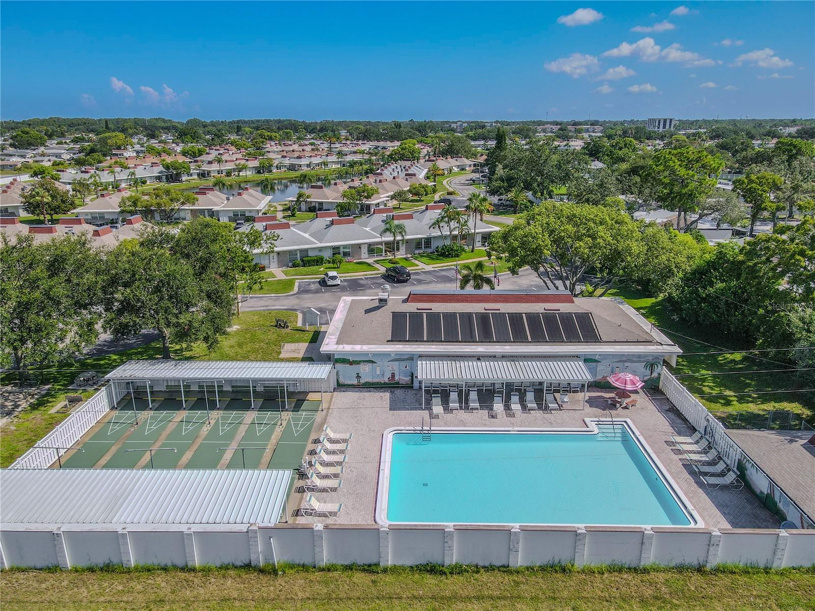 The community clubhouse serves as the heart of this vibrant senior condo community, featuring a spacious, fenced-in resort-style pool perfect for sun-soaked relaxation or socializing with friends. Adjacent to the pool, a shuffleboard area adds a touch of friendly competition and fun, all set amidst beautifully landscaped grounds. This inviting space offers the ideal combination of leisure, activity, and community, making every day feel like a vacation.