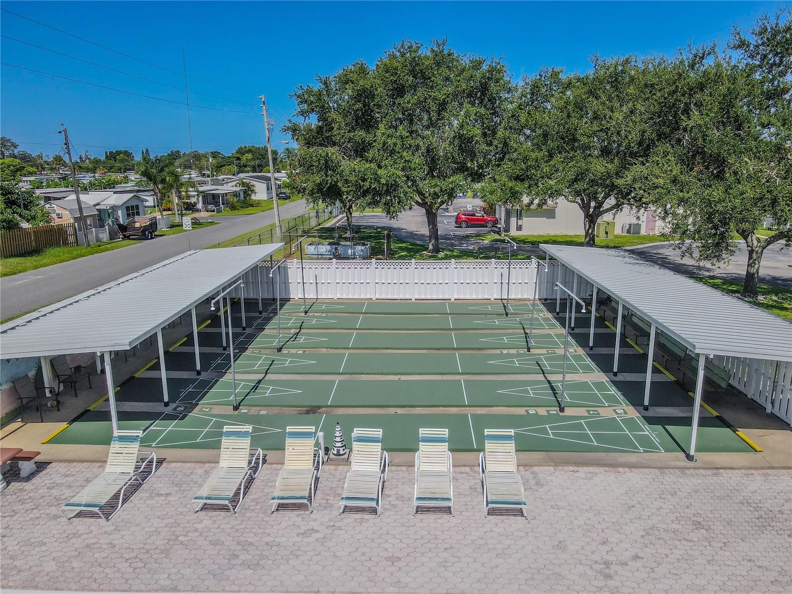 Along side of the beautiful community resort-style pool there is well maintained shuffle board area with covered awnings lights for the evenings, which also serves as a gathering spot, providing a fun and inviting atmosphere for residents.