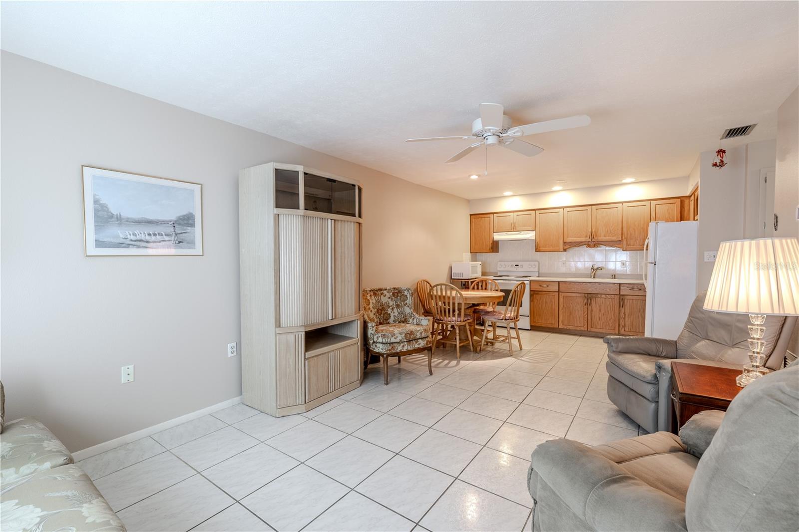 Step into a bright, open living space where the kitchen and living area flow seamlessly together, creating a welcoming and airy atmosphere. Sunlight fills the room, highlighting the spacious layout that’s perfect for entertaining friends, enjoying family time, or simply relaxing in comfort. The open design invites connection and easy movement, making the heart of the home both functional and inviting.