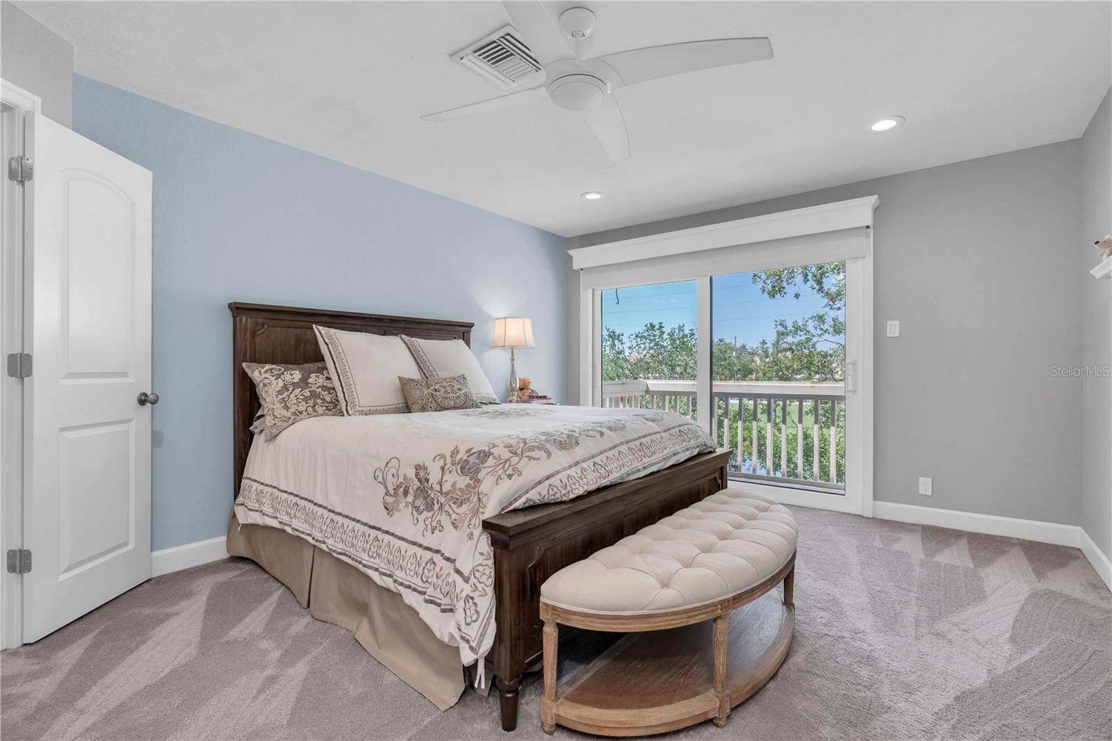 Primary suite with sliding glass doors to balcony overlooking golf course