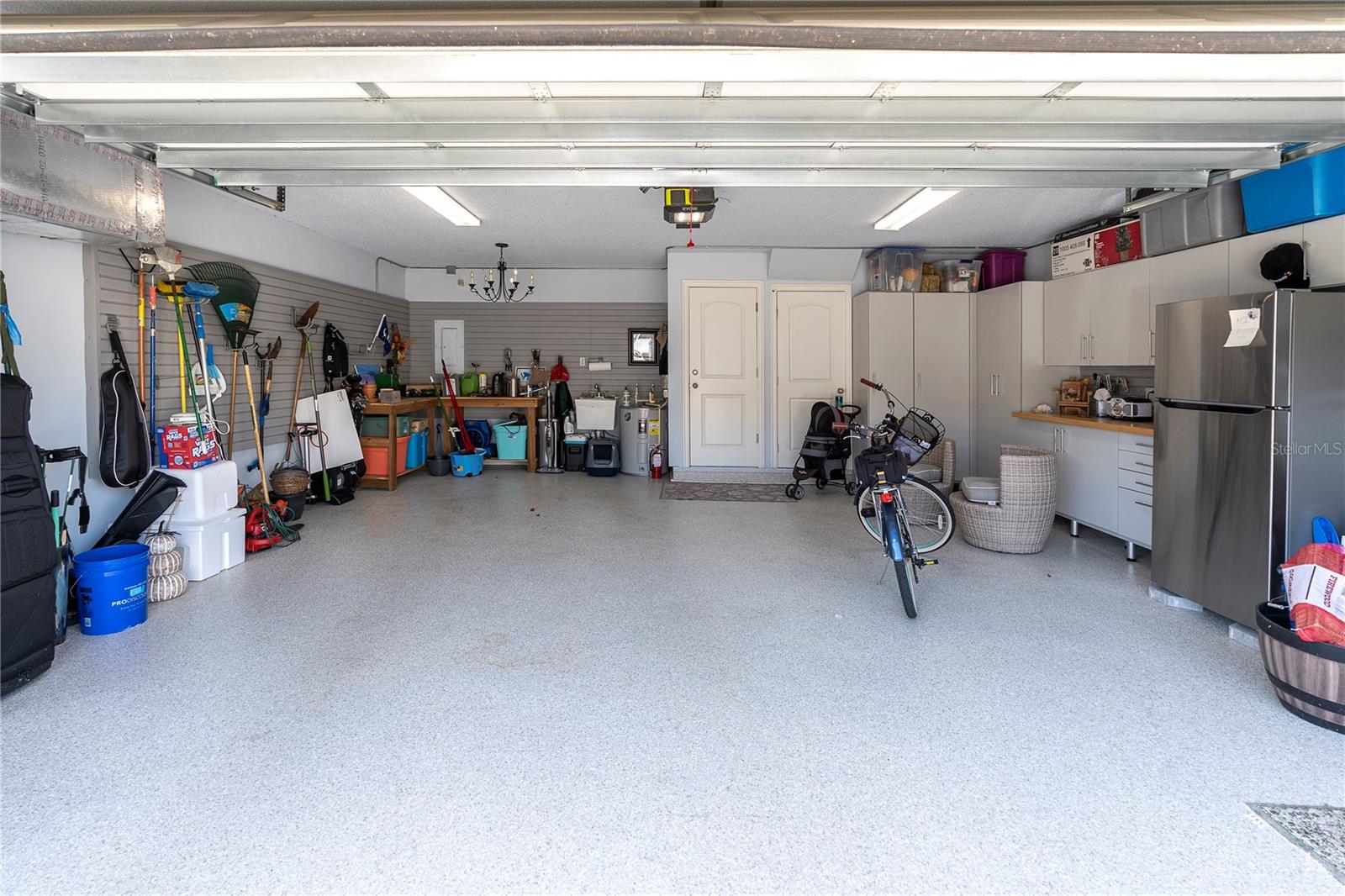 Generous garage with sleek storage cabinet system, water softener, additional storage closet, and wall organization panels