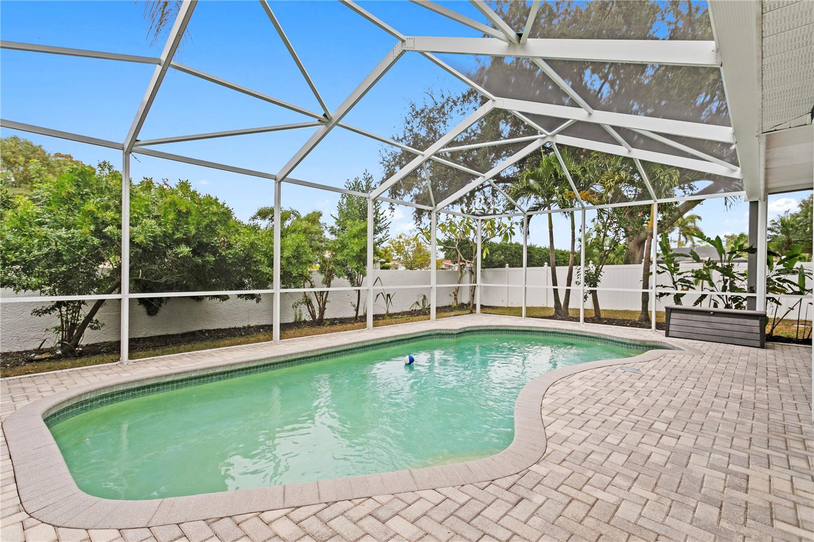 Pool with caged lanaiand fenced backyard