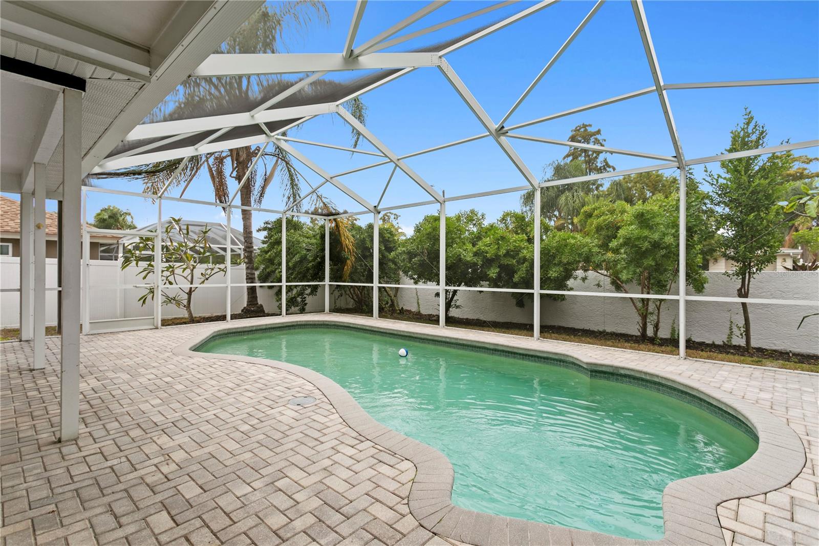 Pool with caged lanaiand fenced backyard