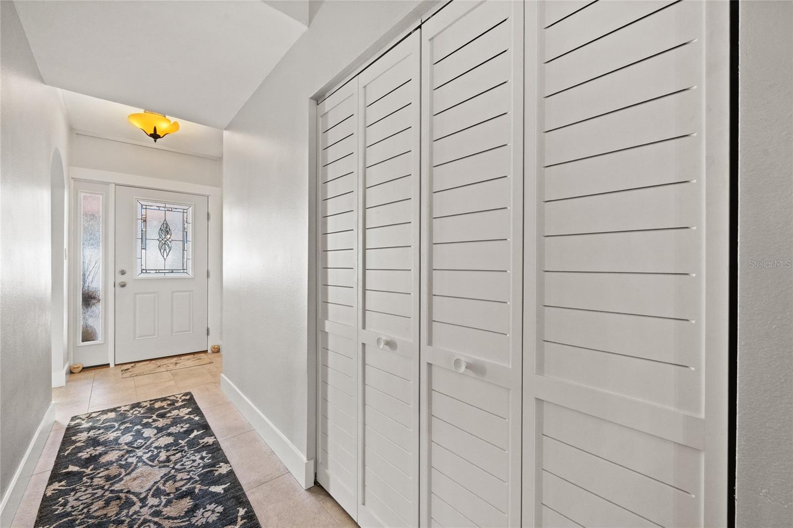 FRONT ENTRANCE AND HALL WITH NEW FRONT DOOR AND CLOSET DOORS