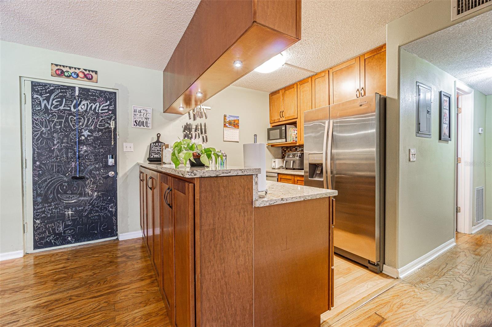 View from living room to front door and kitchen.