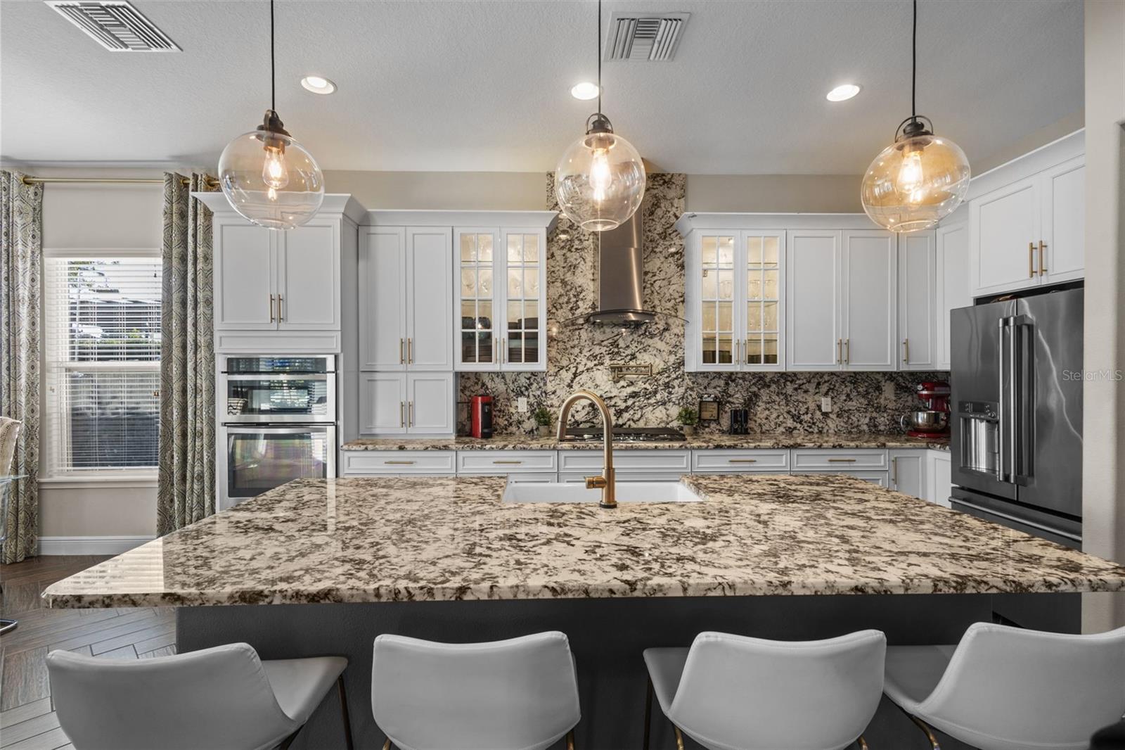 Upgraded chef’s kitchen with white cabinets & gray island