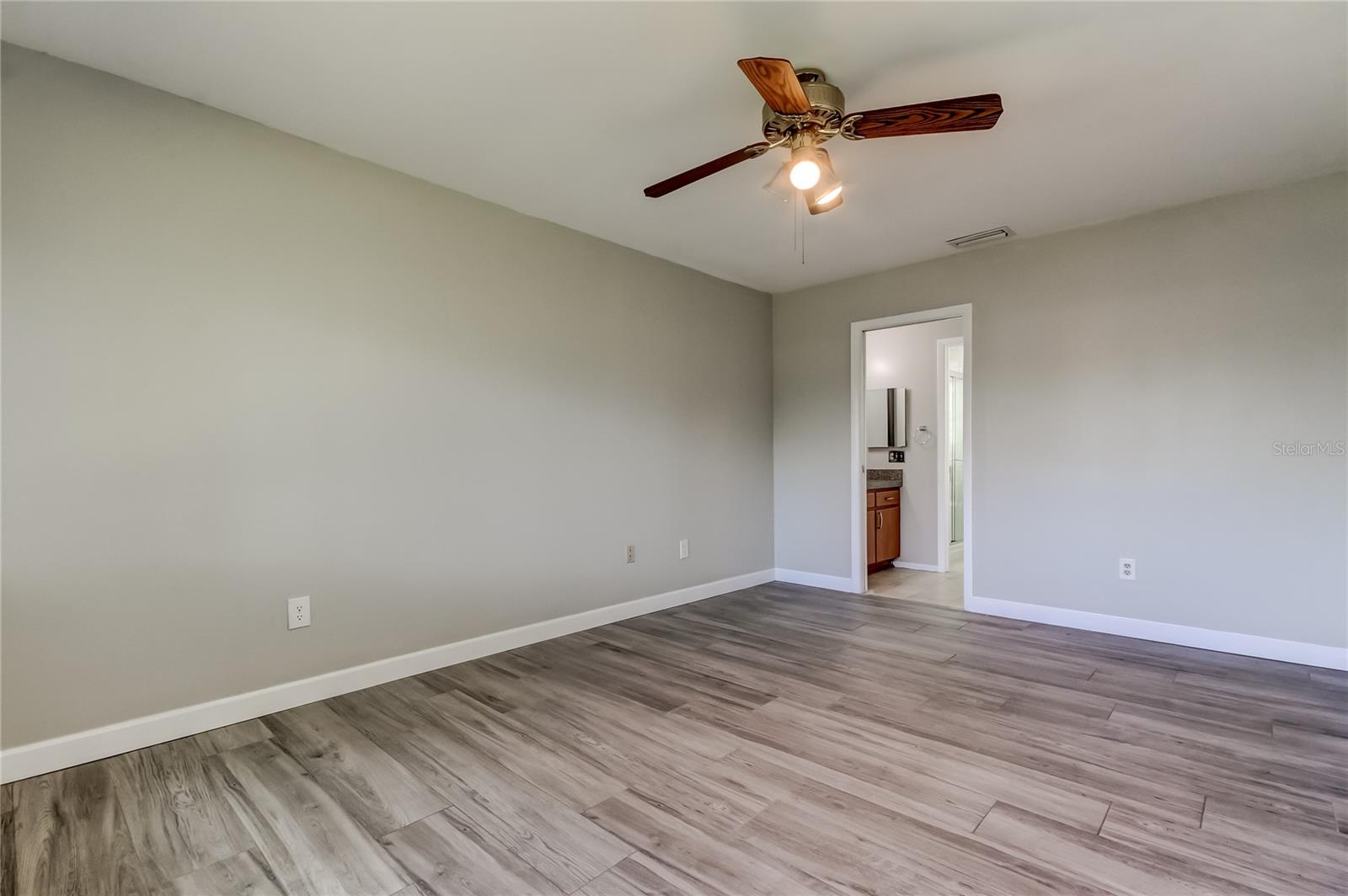 Comfortable and roomy primary suite offering a bright vanity area, a separate walk-in shower with a private water closet, and an expansive walk-in closet with plenty of storage.