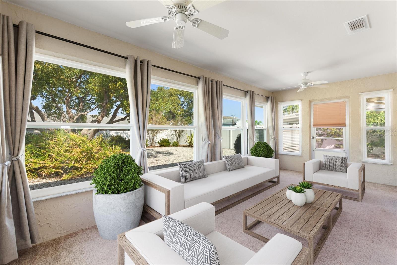 The Florida room with a grand view of the beautiful back yard.   Picture is virtually staged.