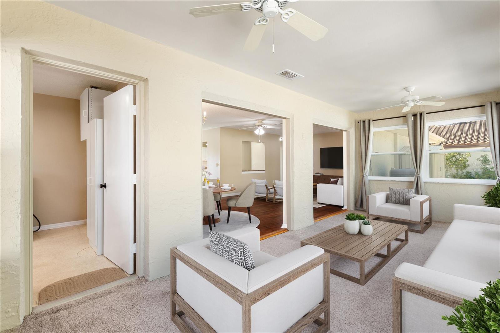 Florida room with view into living and dining room area.  Door to the left leads into the laundry room and garage access.  Picture is virtually staged.