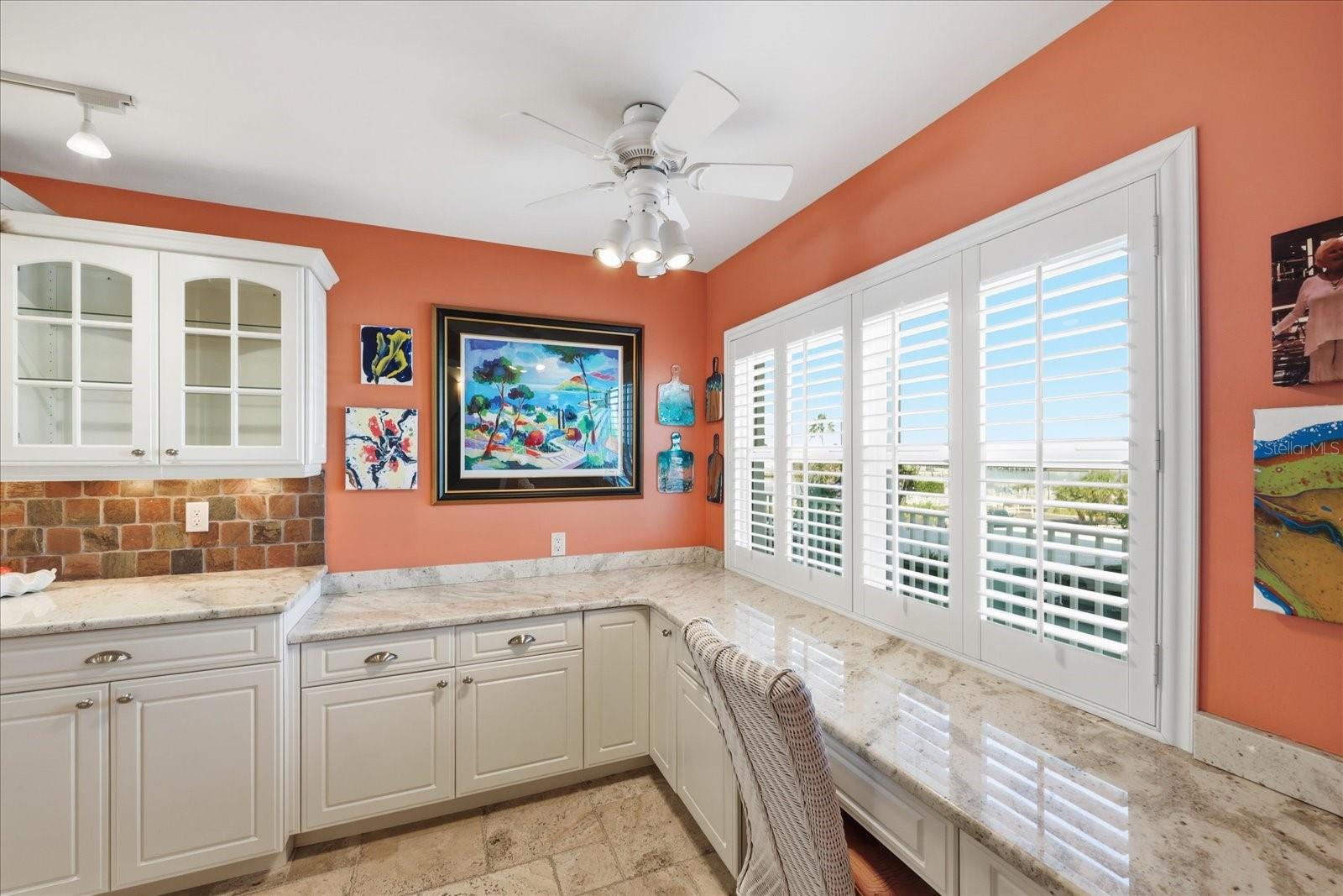 Built in desk area with hurricane rated window and plantation shutters.