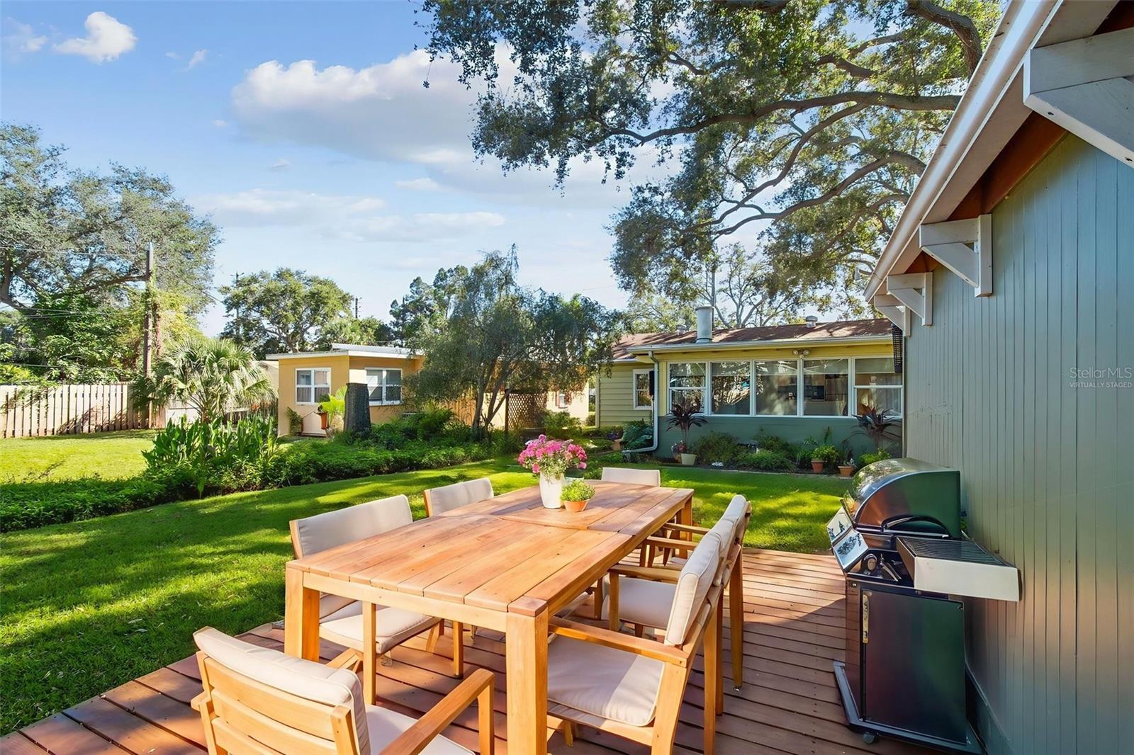 Virtually staged wooden deck by garage.