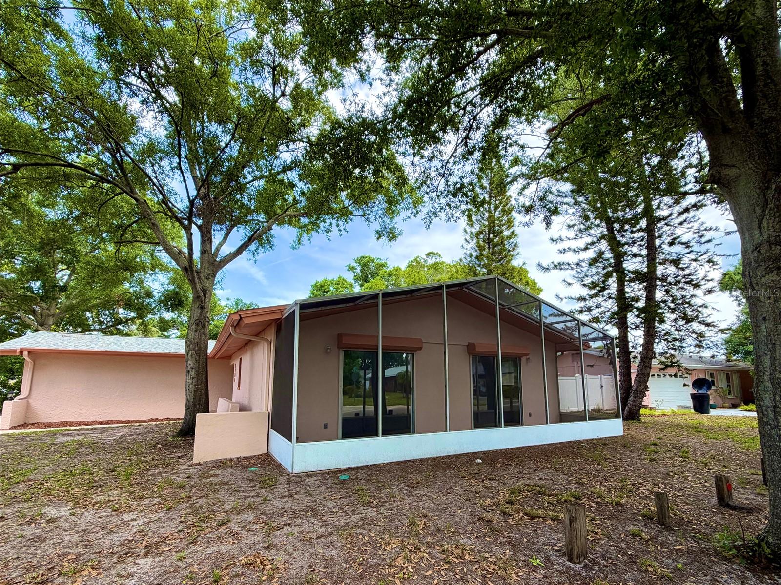 SIDE EXTEROR, SCREENED IN PATIO OFF BEDROOMS