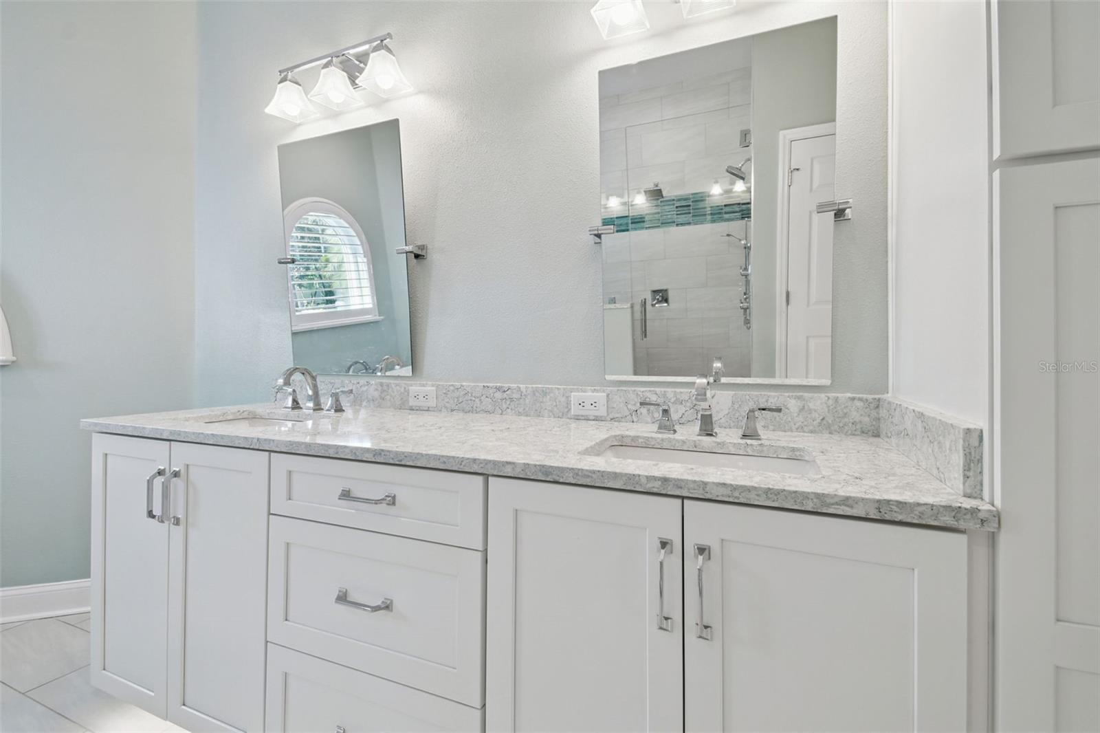 Primary bathroom with dual sinks, quartz countertops, and lots of storage