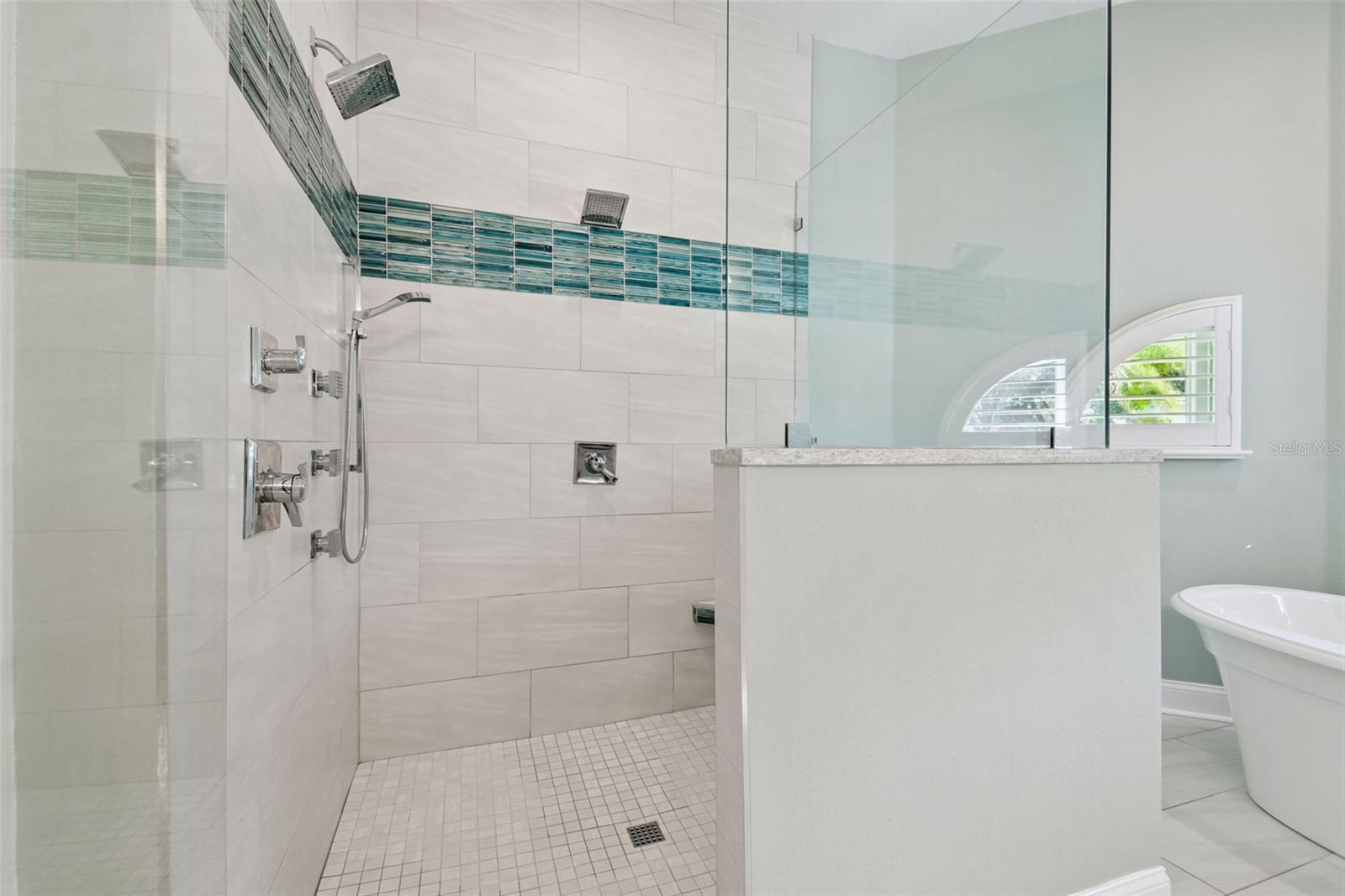 Large walk-in shower with dual shower heads, body jets and a handheld
