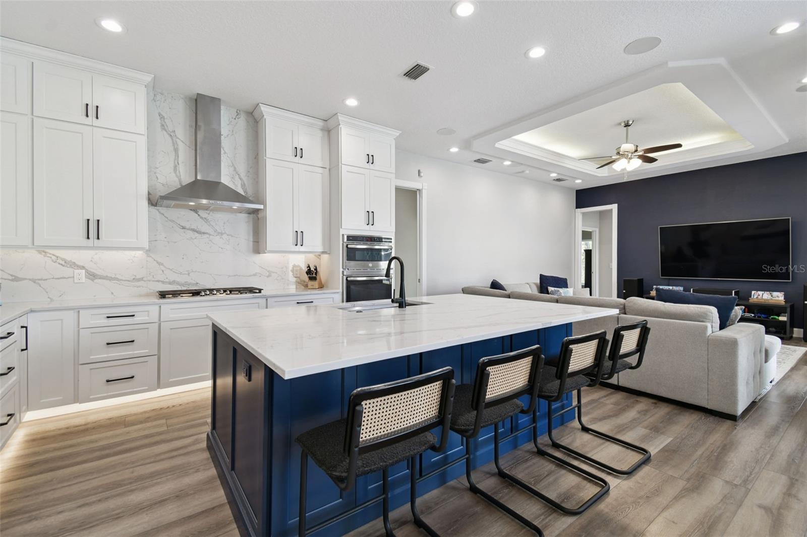 Stunning Kitchen with large island, custom cabinets, quartz countertops & backsplash, and stainless steel appliances