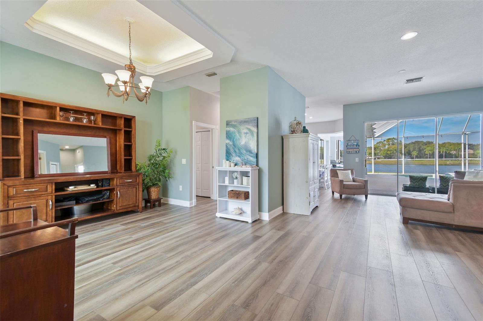 Enter into this light & bright home with open floor plan featuring luxury vinyl plank flooring throughout and peaceful views of the pool and pond