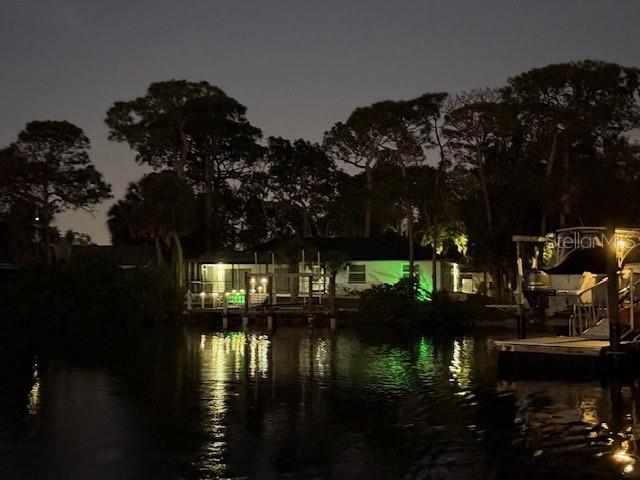 View of the property from the channel at night. Well lit.