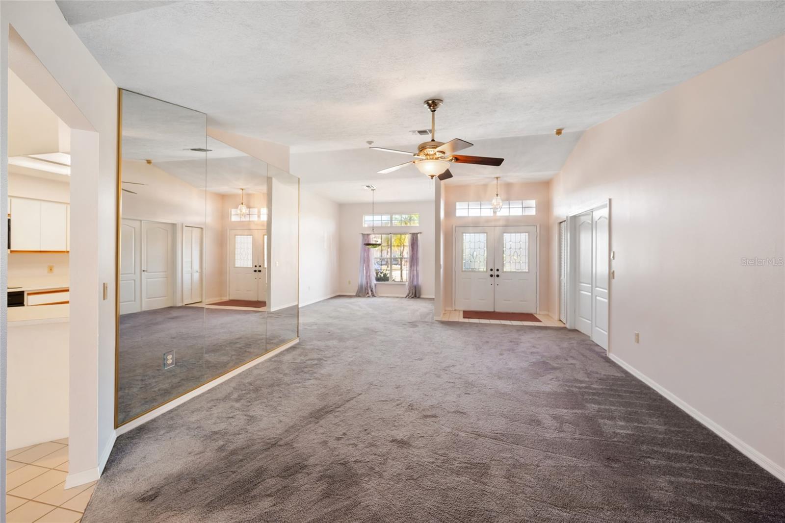 Double door front entry with formal dining room and living room overlooking the pool.