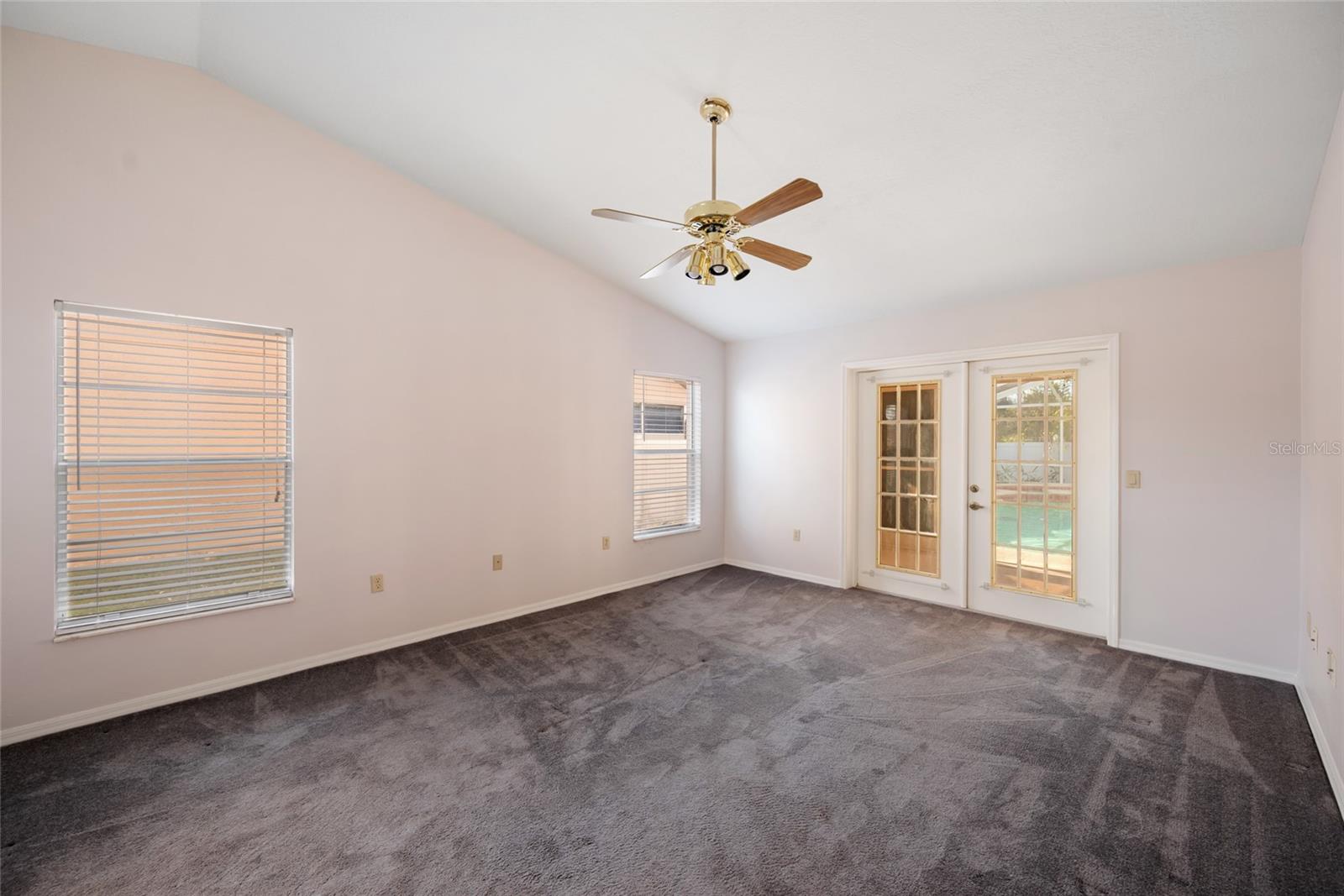 Primary Bedroom with double door entry to the patio and pool.