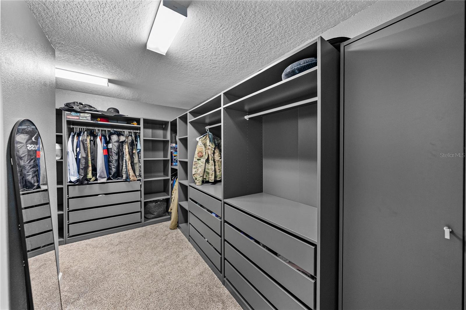 Primary closet has built in shelfing and wraps around the laundry room