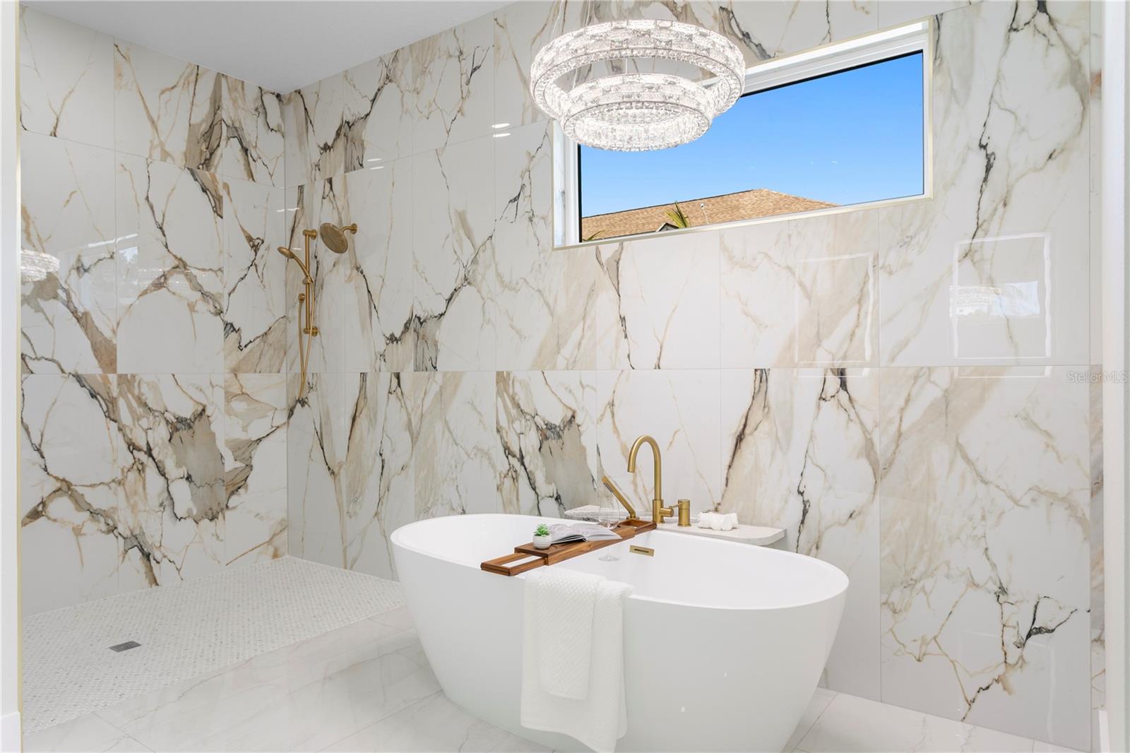 Freestanding Tub Illuminated by a Statement Chandelier