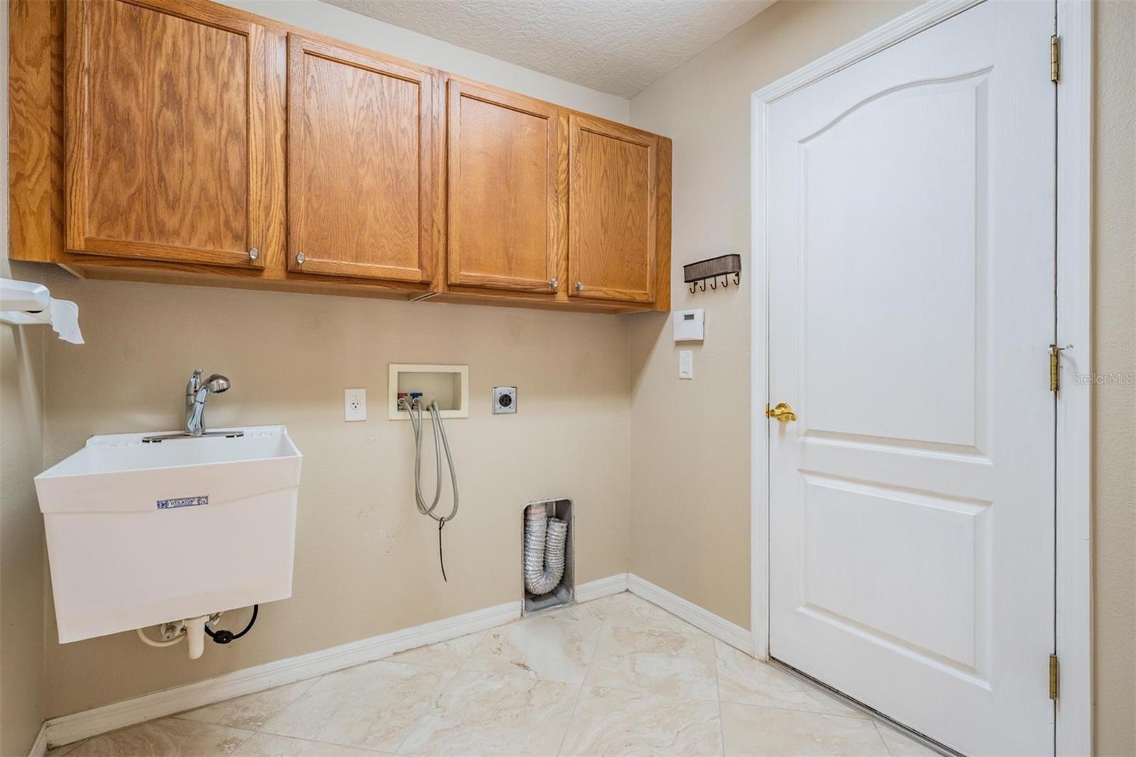 Walk-in laundry room with built-ins and utility sink