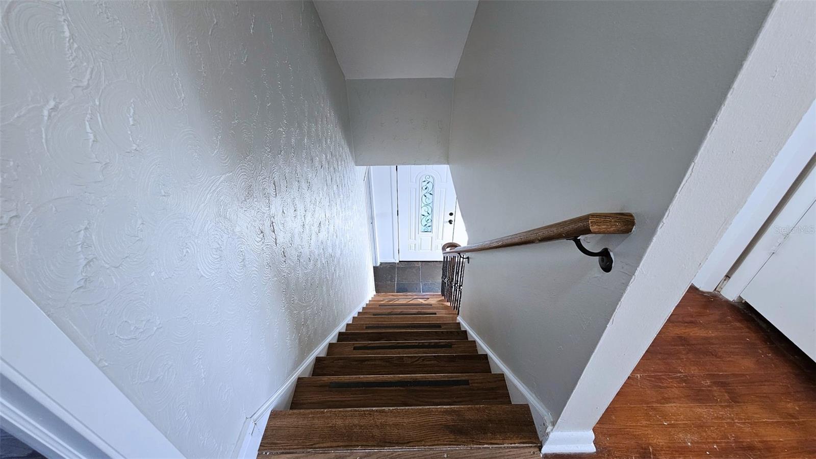 Stairway accessible from dining area and living area. Front door at bottom