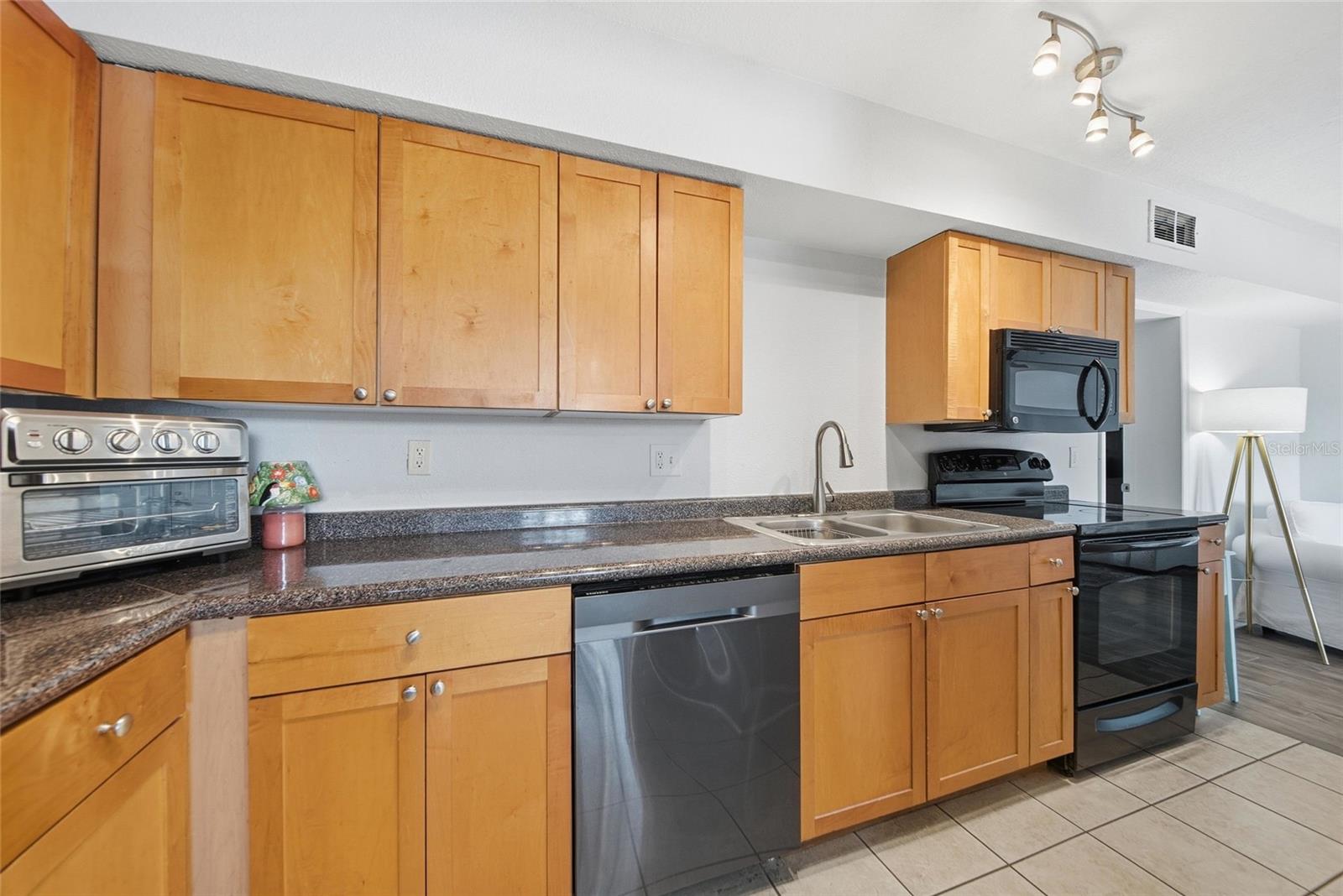 The kitchen is outfitted with a microwave, oven, dishwasher, refrigerator, and disposal.