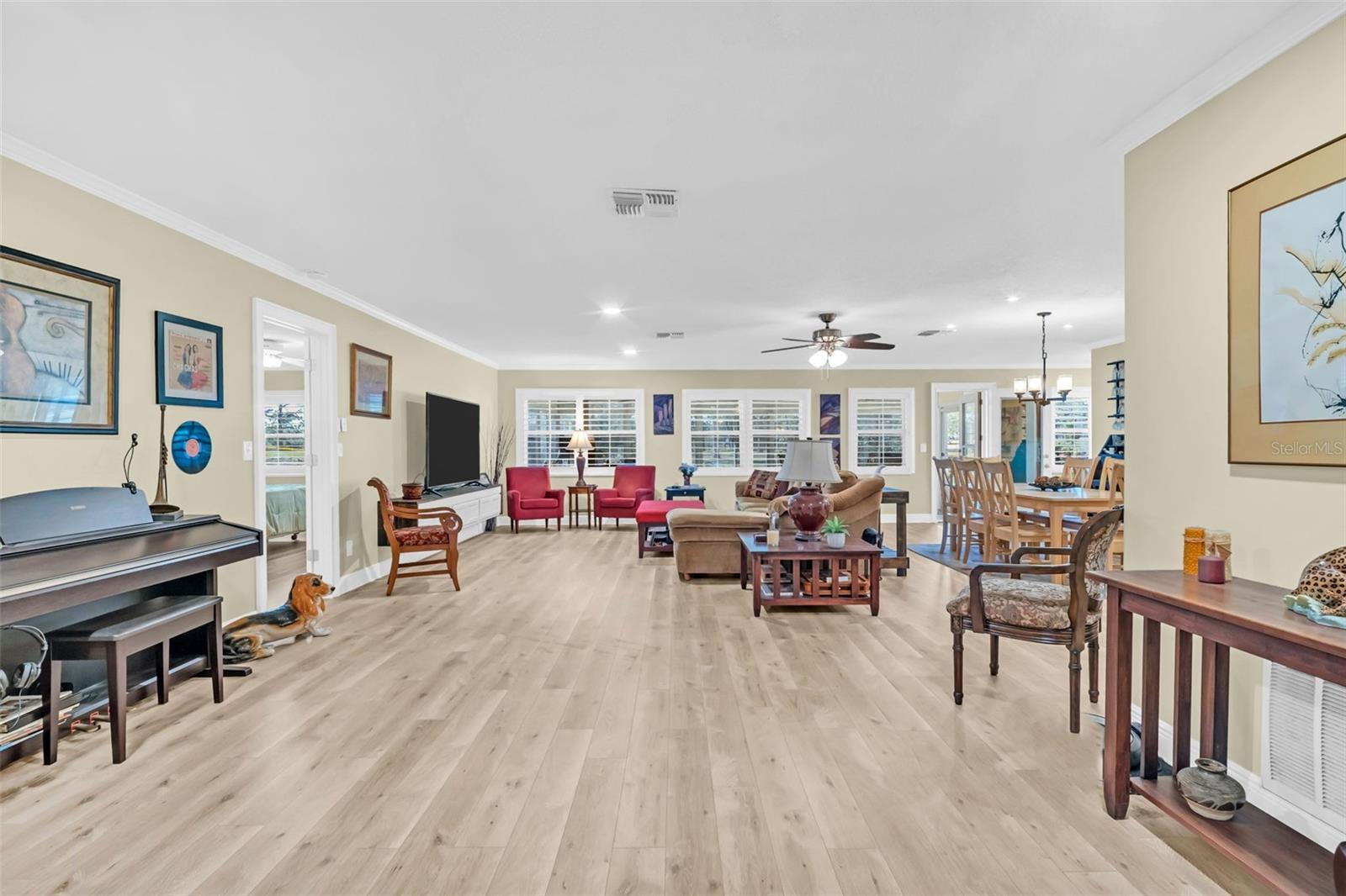 The lovely home has been updated with recessed lighting - light colored laminate flooring - crown molding - modern high baseboards and plantation shutters throughout.