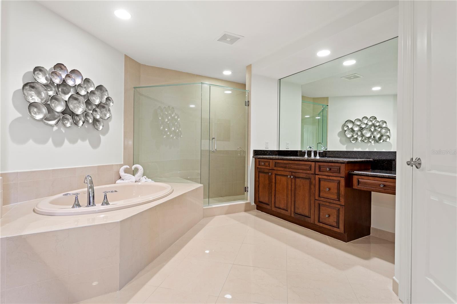 The expansive primary bathroom is a serene retreat, featuring dual vanities, a soaking tub, and large shower.