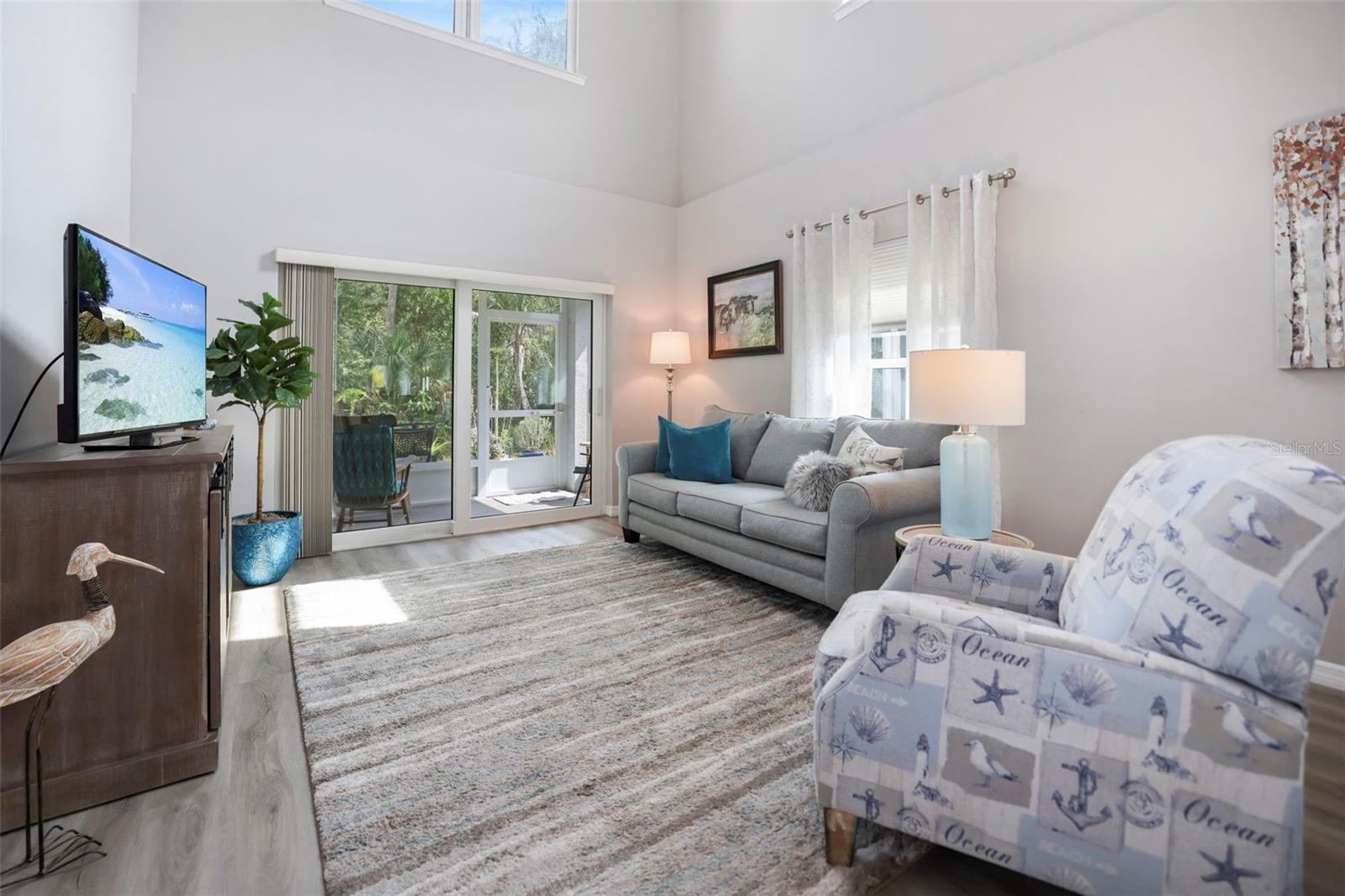 Living room leads to screened lanai and outdoor patio