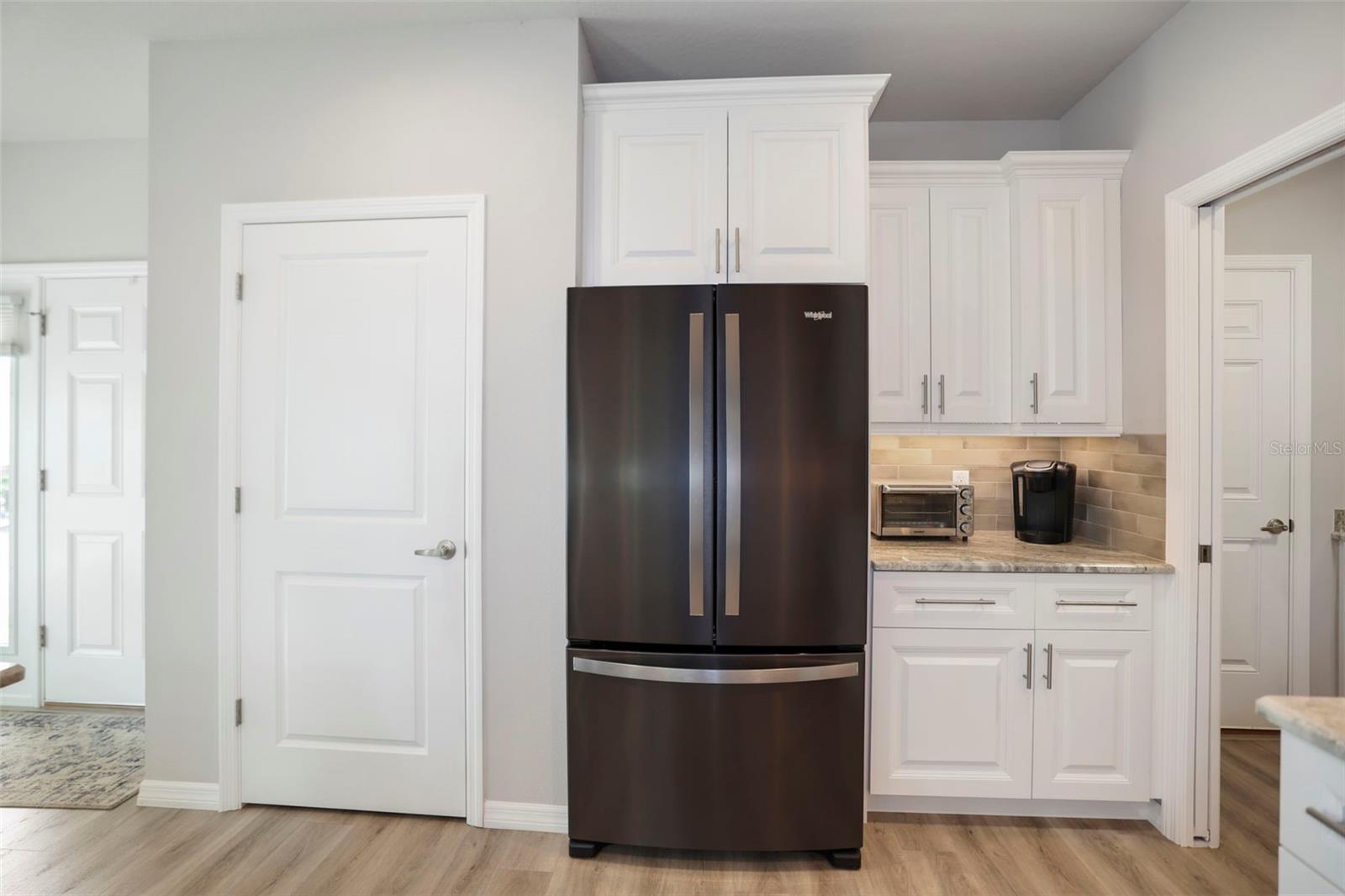 Large pantry and coffee area next to refrigerator
