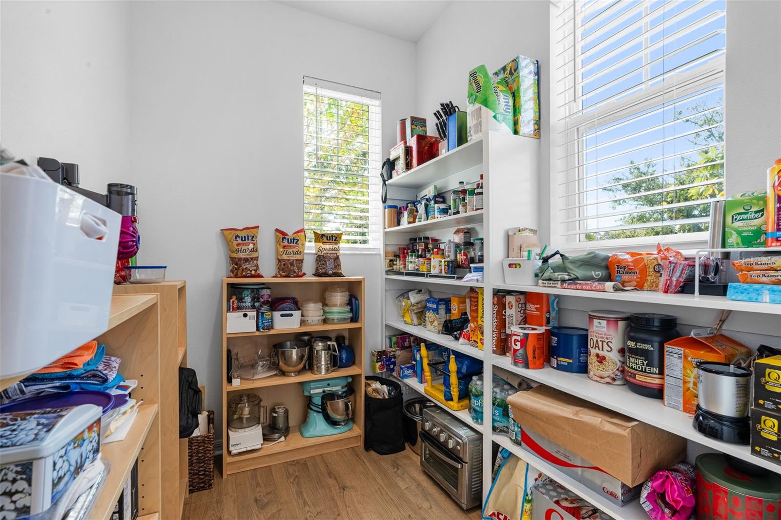 Massive walk in pantry with built in shelving and two windows!