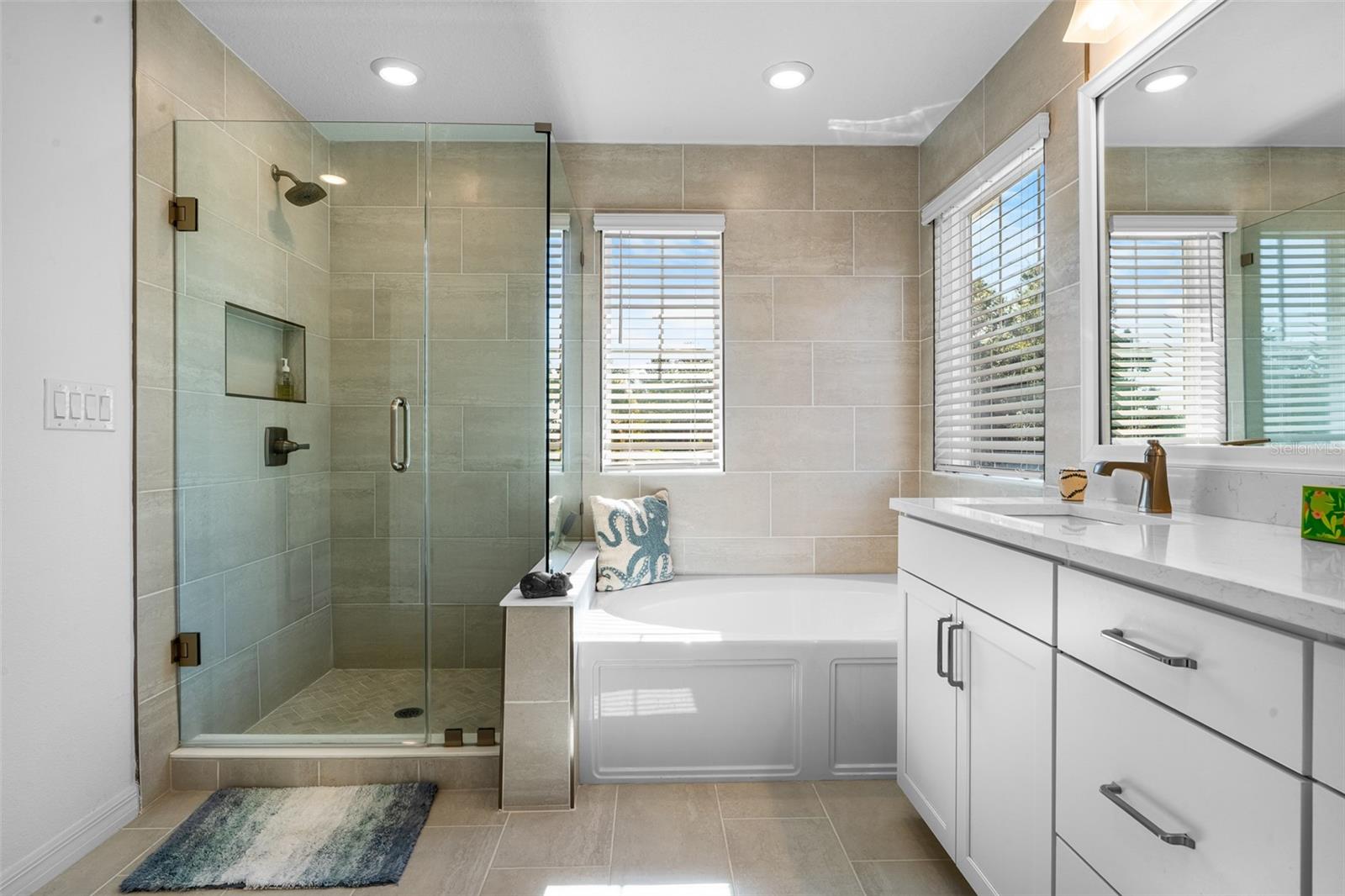 Primary en suite bath with a walk in shower, soaking tub and lots of natural light.