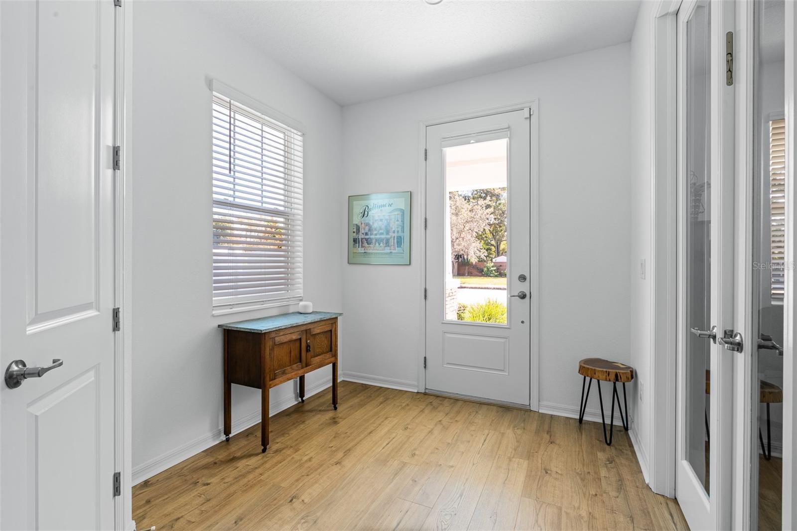 Light and bright entryway with office on the right side behind the glass doors.