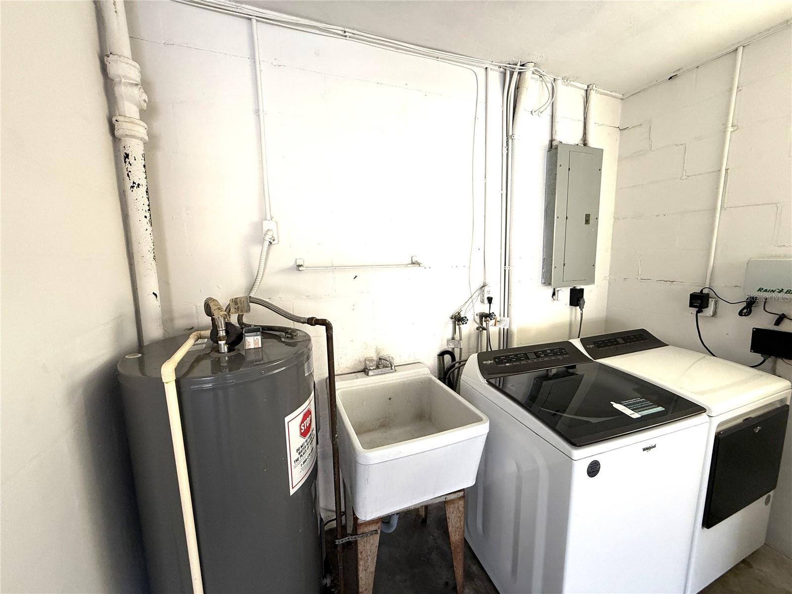 Good view of laundry sink, washer and dryer hook ups in the garage.