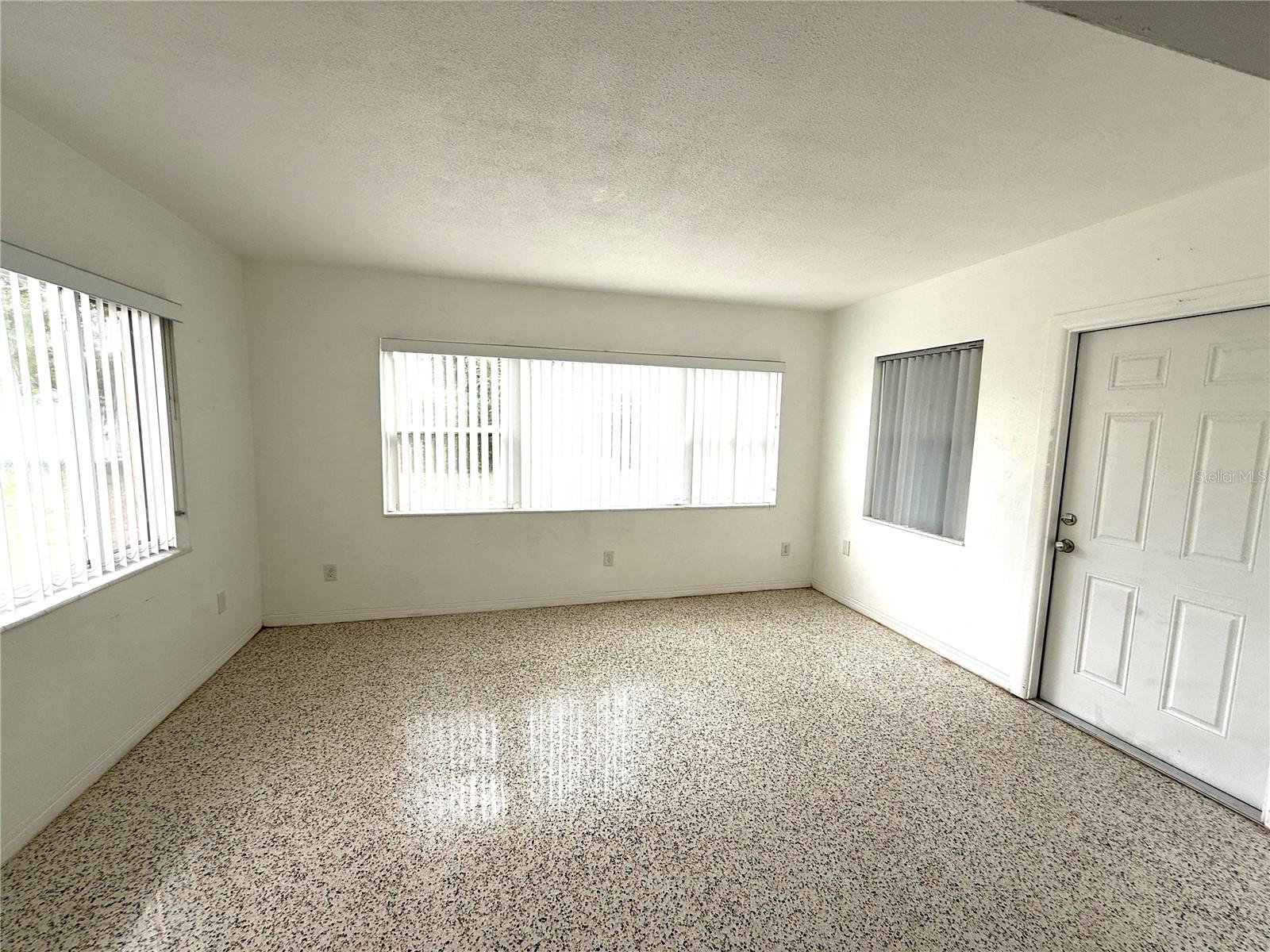 Family room bright w/natural light. Door on right opens to screened and roofed lanai.