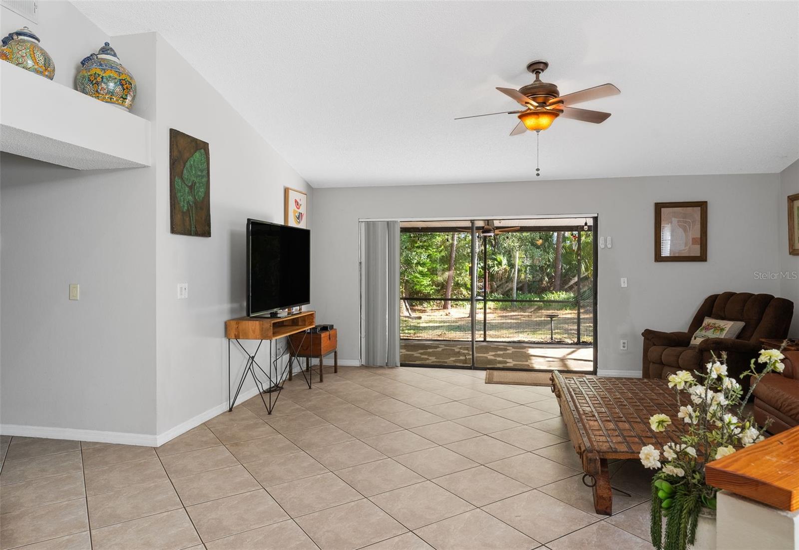 View of family room with of expansive lanai and backyard.