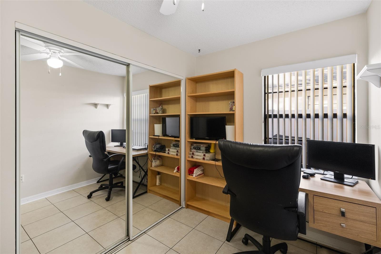 Bedroom 2 with full wall of closet and mirrored doors.